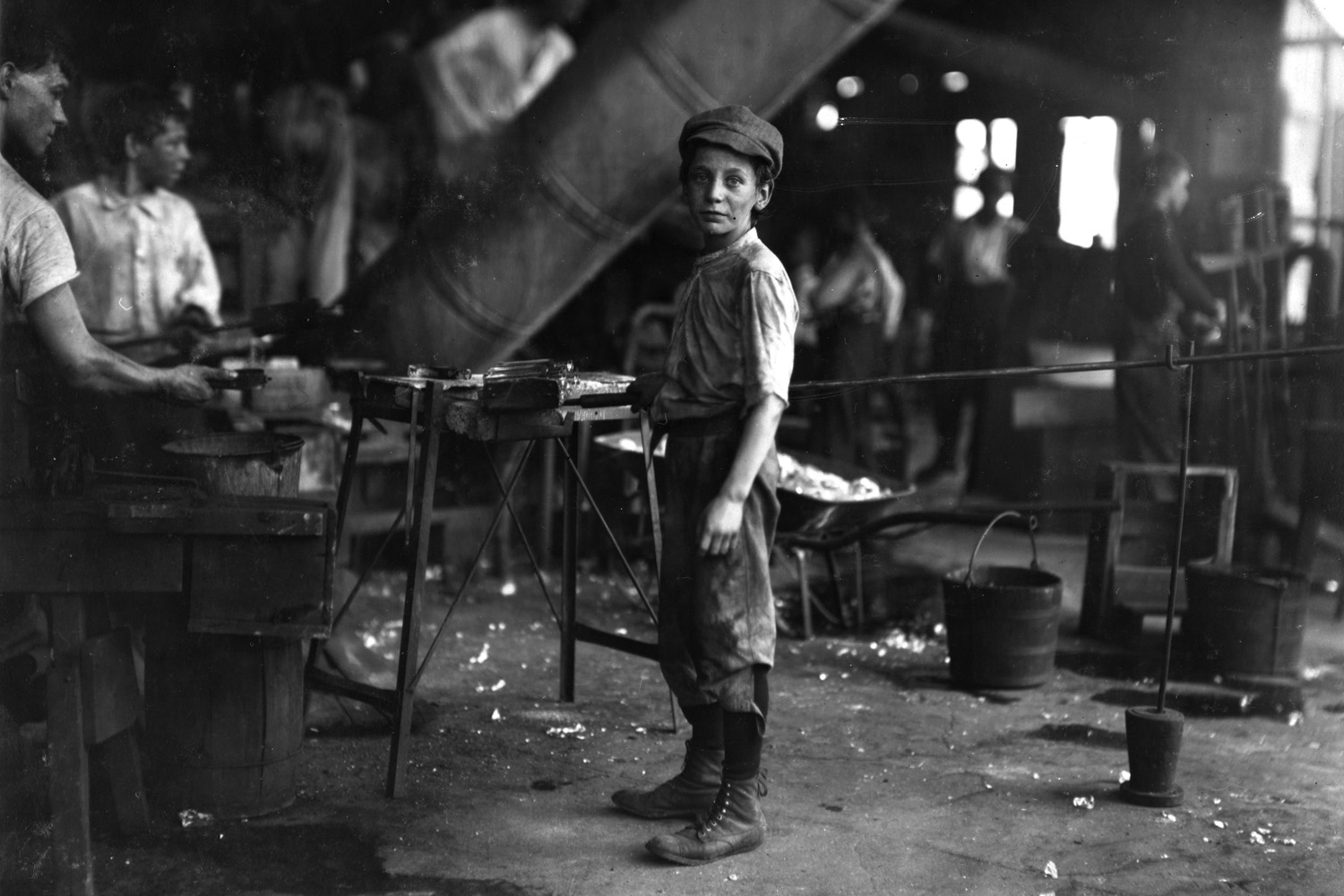 <i>Each of the following slides contain Manning's field notes on his subjects, whether quotes from their descendents or facts he uncovered about their lives. We've also included Hine's original captions when available. Click on the subject's name to view Manning's full research.</i><br><br><b><a href="http://www.morningsonmaplestreet.com/robertkidd1.html">Robert Kidd, glass factory worker, 12 years old, Alexandria, Virginia, 1911.</a></b>
<br><br>
"'Carrying-in' boy in Alexandria Glass Factory. Works on day shift one week and night shift next week." —Hine's original caption
<br><br>
“He always had that [sad] expression. I take after him, because everybody tells me I look the same way, sad all the time. He was an alcoholic, but I loved my father. He wasn't mean. He was a good father, other than the sickness he had with alcohol. He was always good to us. I remember one time when I was sick, he brought me some oranges. He loved his children. He was always concerned about us.” —Daughter o