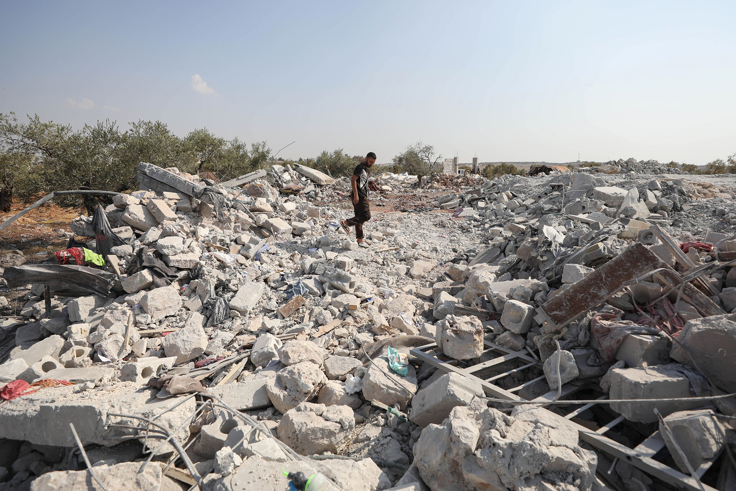 A Syrian man inspects the site of helicopter gunfire near the northwestern Syrian village of Barisha on Oct. 27, 2019.