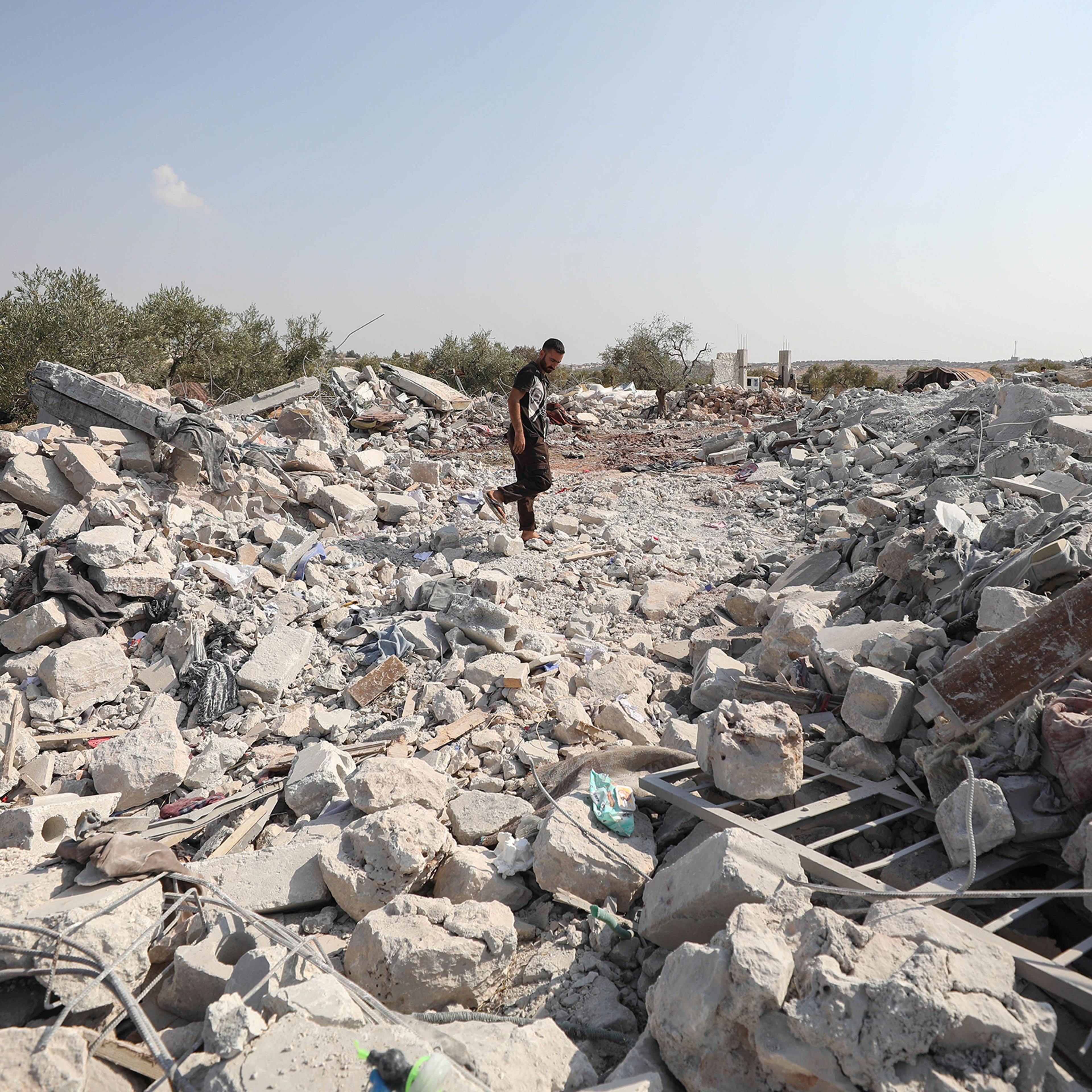 A Syrian man inspects the site of helicopter gunfire near the northwestern Syrian village of Barisha on Oct. 27, 2019.
