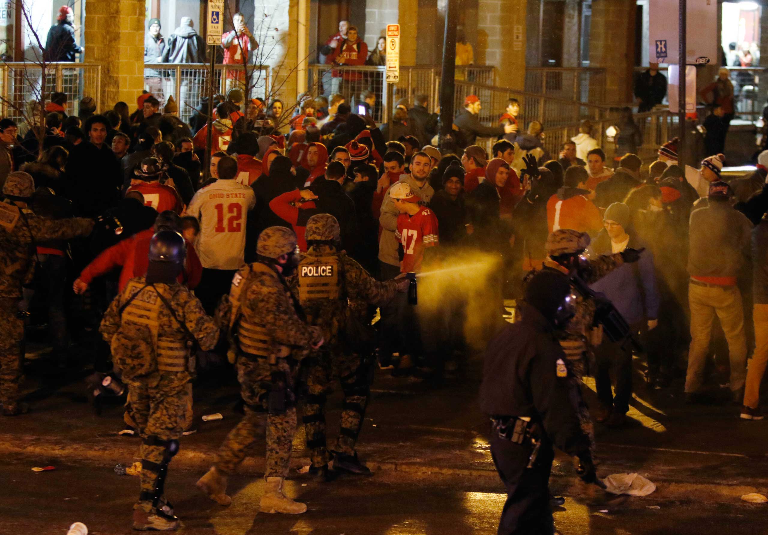 Police officers try to disperse the crowd of Ohio State fans trying to block High Street in Columbus, Ohio, as they celebrate the Buckeye's 42-20 win over Oregon following the National Championship football game between Ohio State and Oregon, Jan. 12, 20