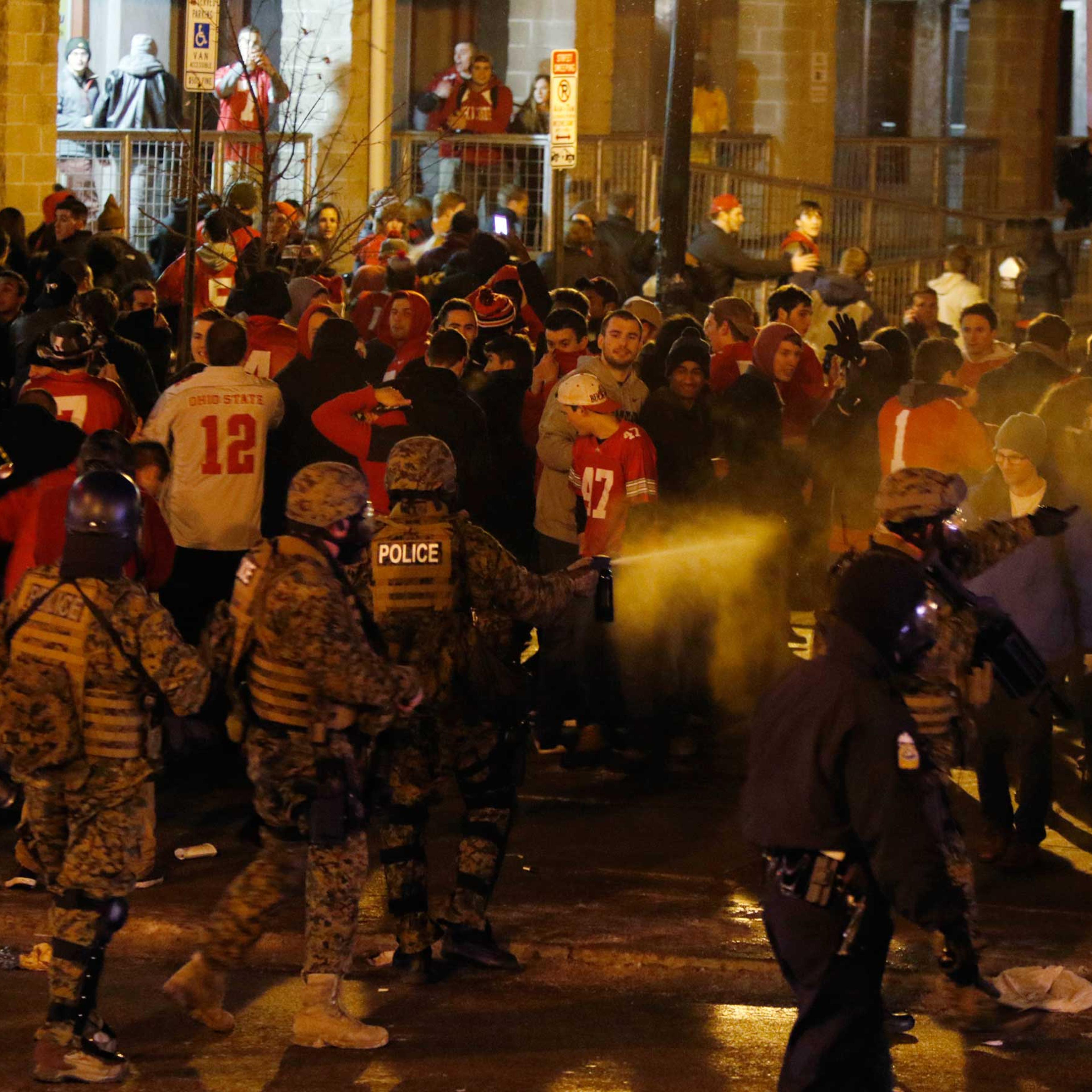 Police officers try to disperse the crowd of Ohio State fans trying to block High Street in Columbus, Ohio, as they celebrate the Buckeye's 42-20 win over Oregon following the National Championship football game between Ohio State and Oregon, Jan. 12, 20