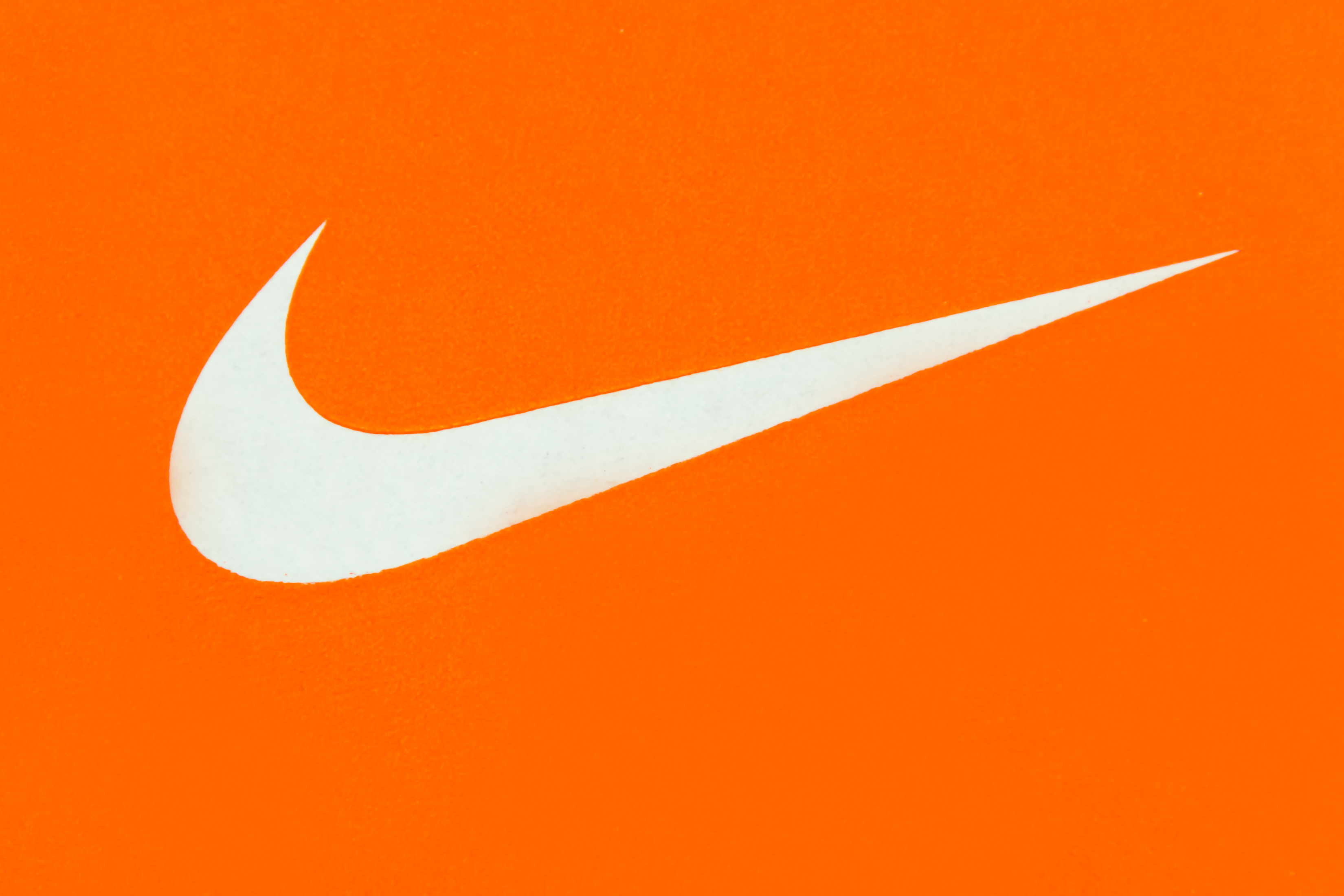 White Nike Logo on Orange Background