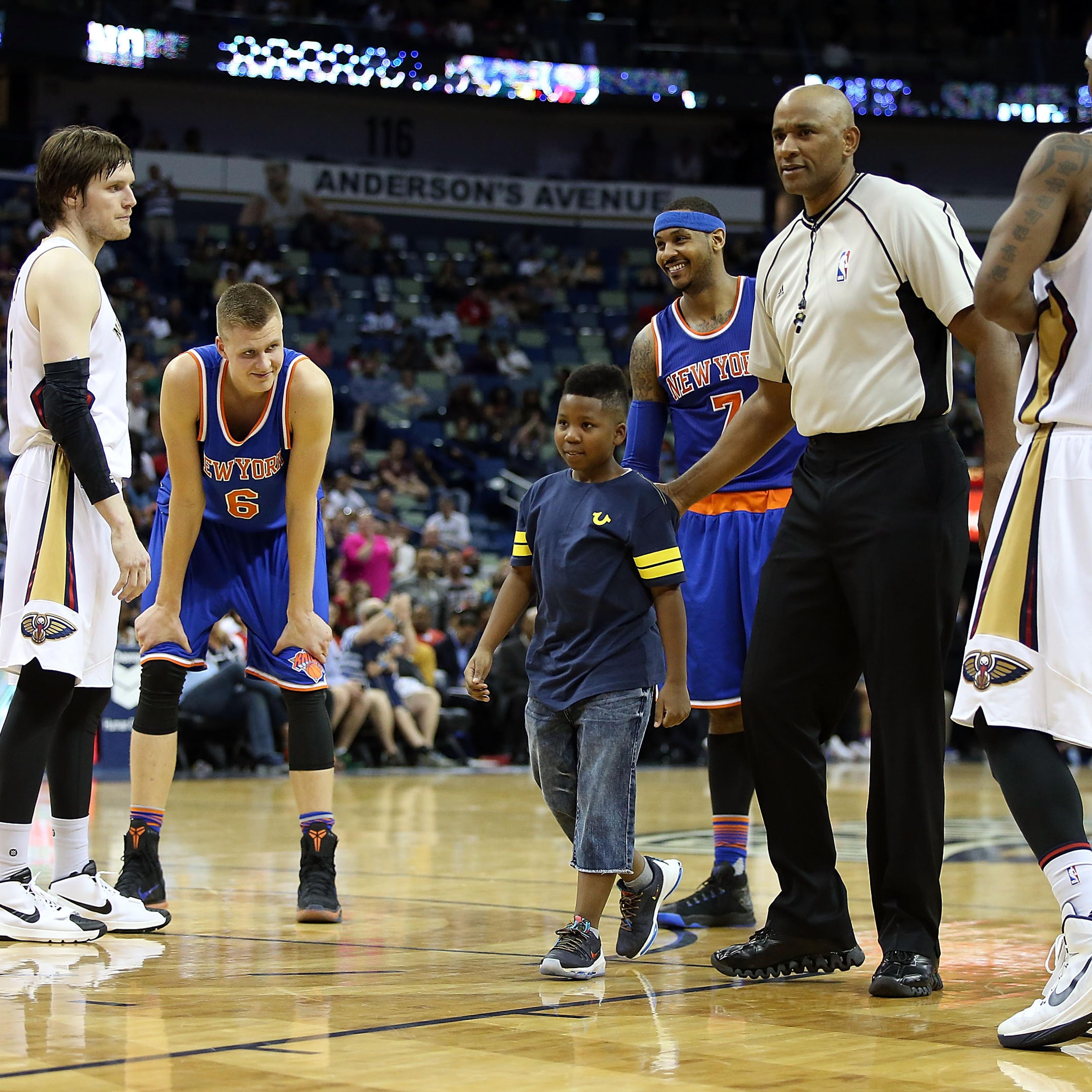 A young boy is escorted off the court after hugging Carmelo Anthony #7 of the New York Knicks during a game against the New Orleans Pelicans during the second half at the Smoothie King Center on March 28, 2016 in New Orleans, Louisiana.