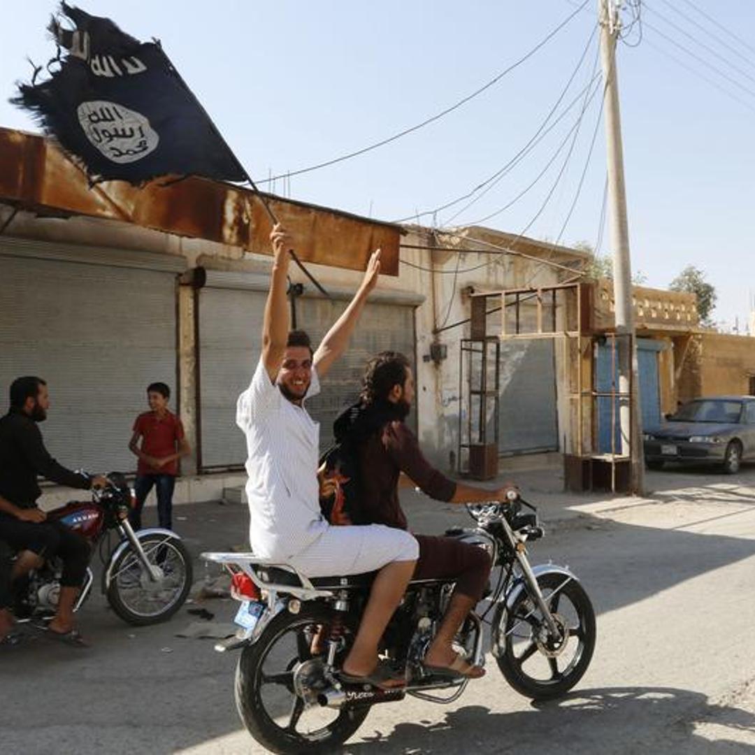 Resident of Tabqa city touring the streets on a motorcycle waves Islamist flag in celebration after Islamic State militants took over Tabqa air base, in nearby Raqqa city