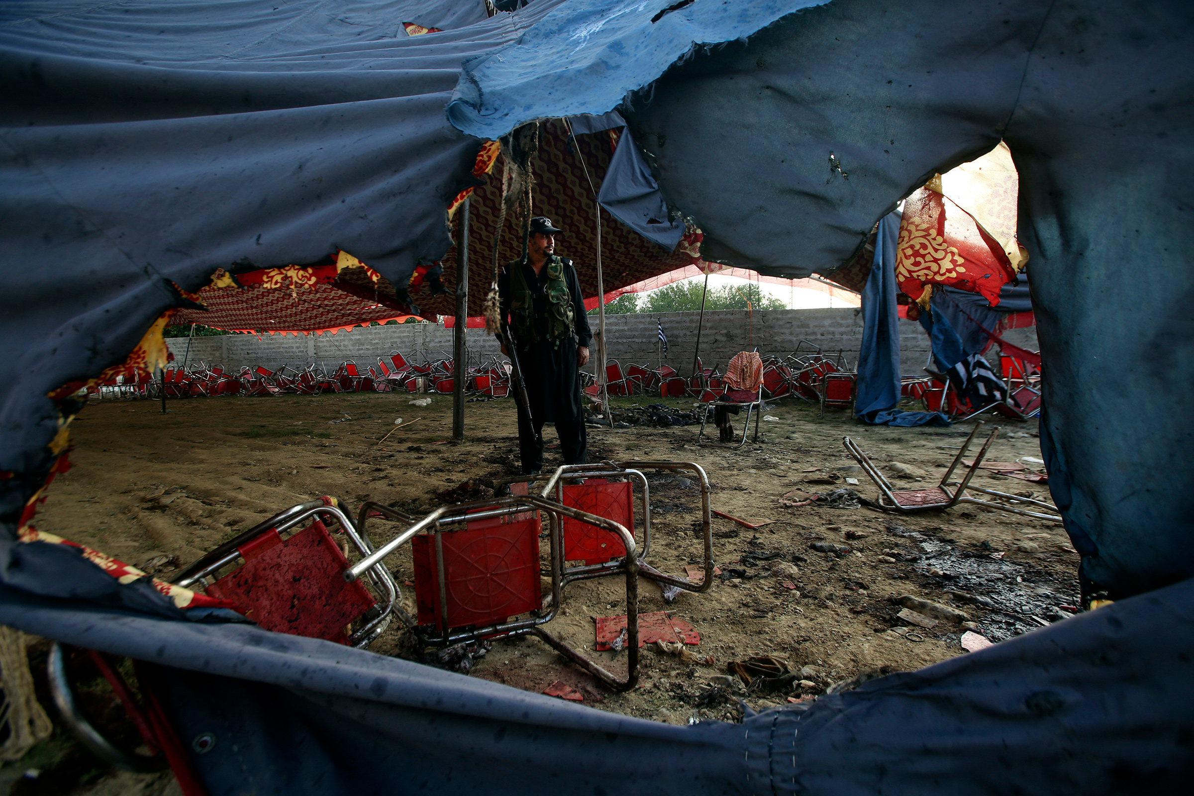 A Pakistani police officer stands guard at the site of Sunday's suicide bomber attack in the Bajaur district of Khyber Pakhtunkhwa, Pakistan, on July 31.