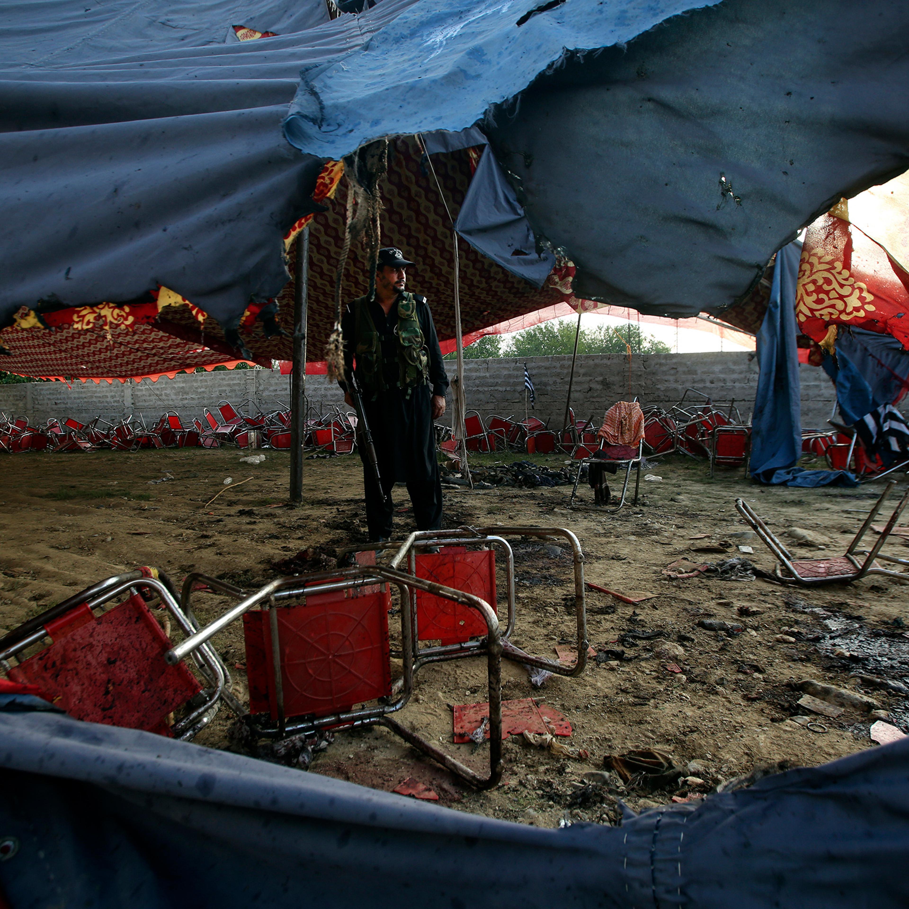 A Pakistani police officer stands guard at the site of Sunday's suicide bomber attack in the Bajaur district of Khyber Pakhtunkhwa, Pakistan, on July 31.