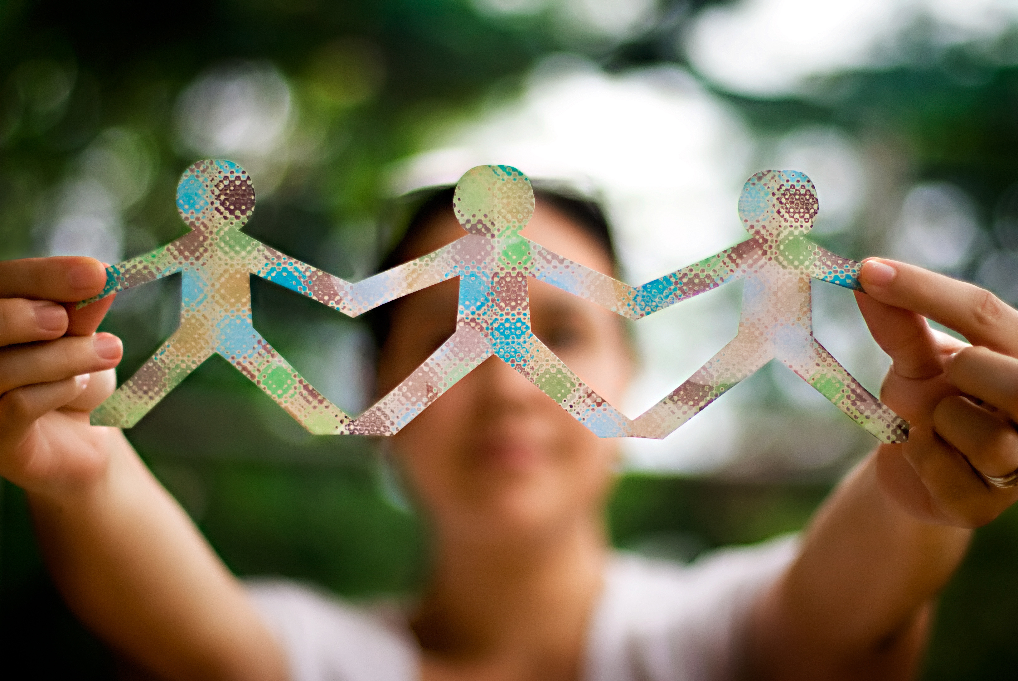 Woman holding up a colorful people paper chain