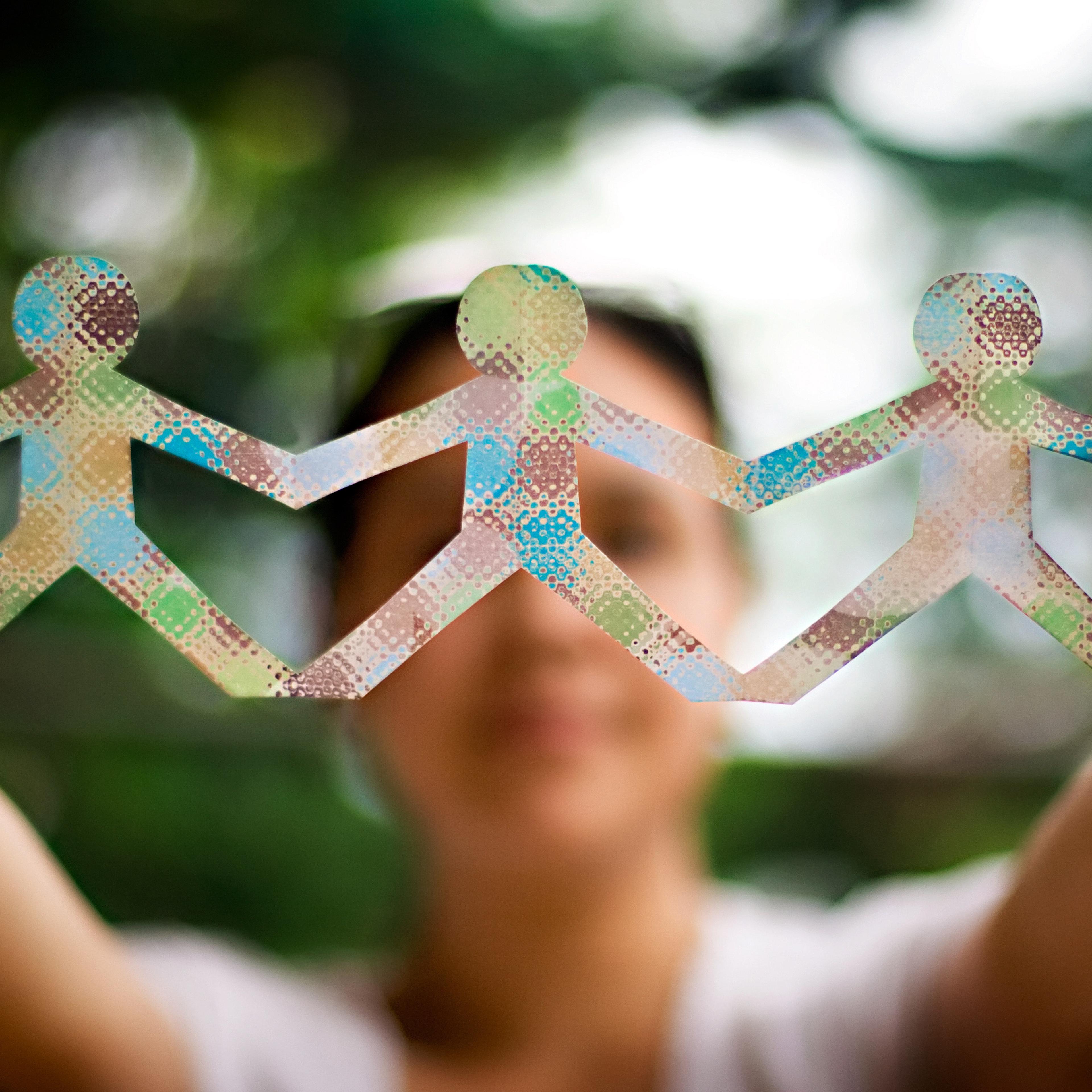Woman holding up a colorful people paper chain