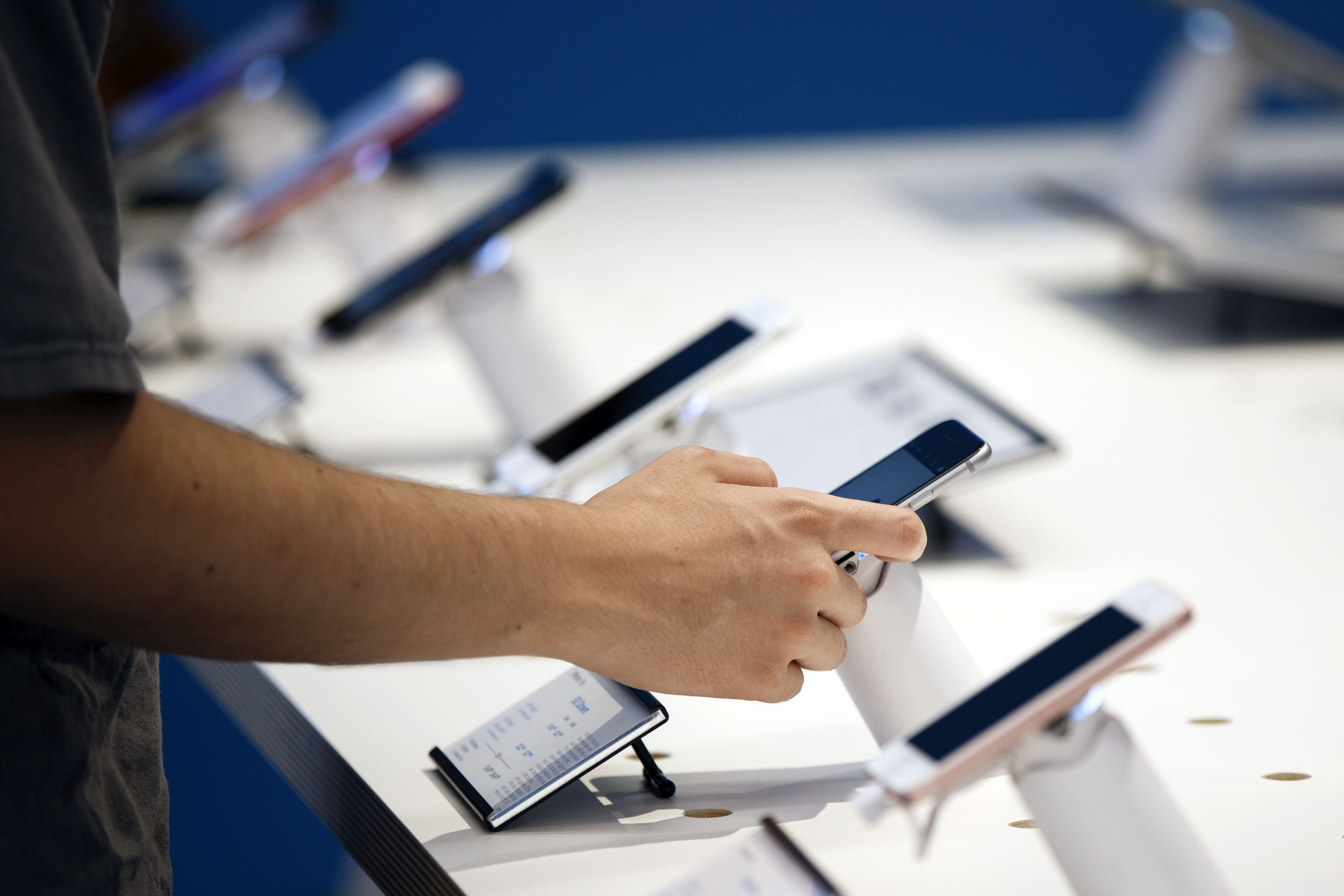 A customer browses Apple iPhones at an AT&T store in Newport Beach, Calif. on Aug. 10, 2017.