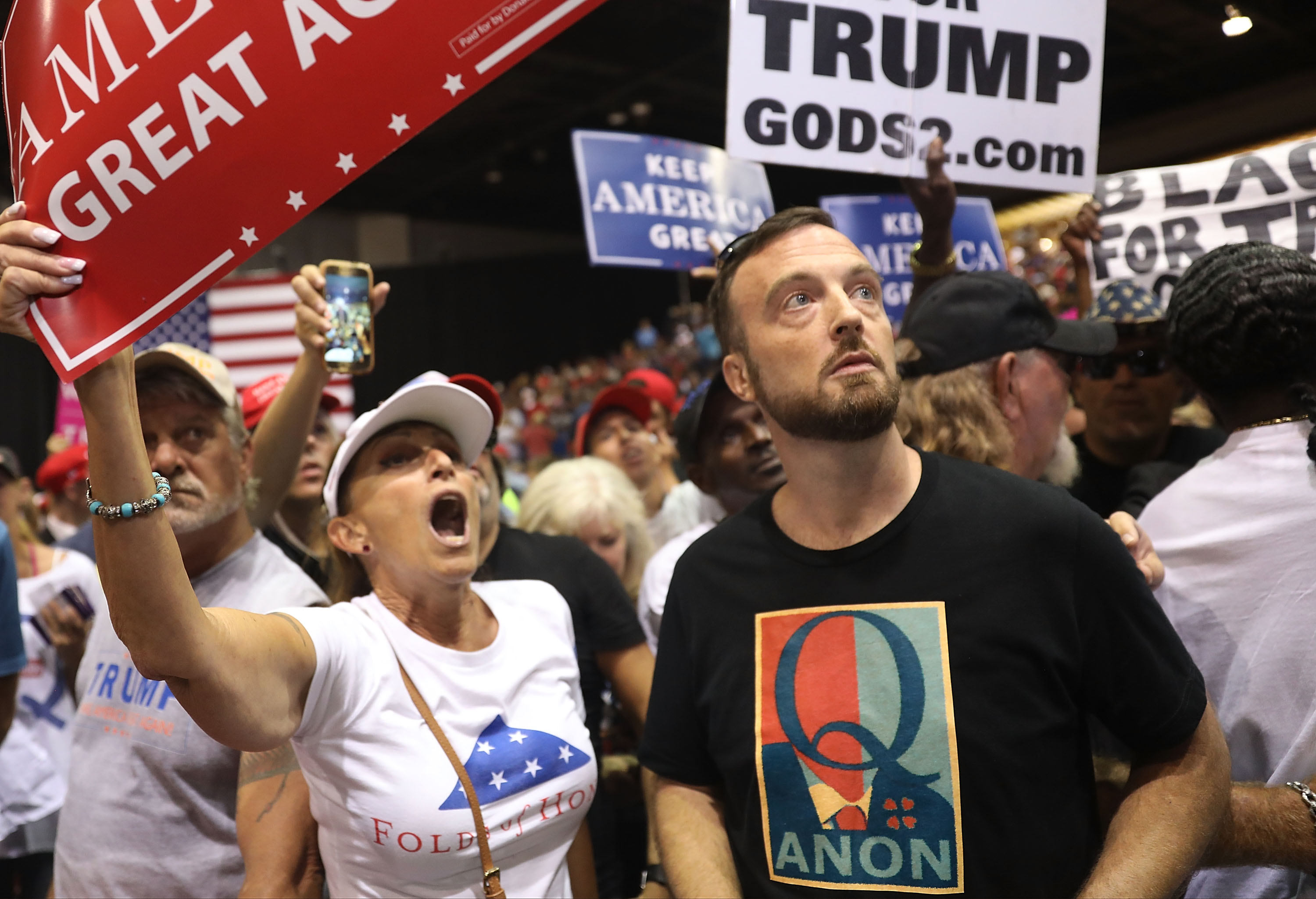 A man with the words Q Anon on his shirt at the Trump rally