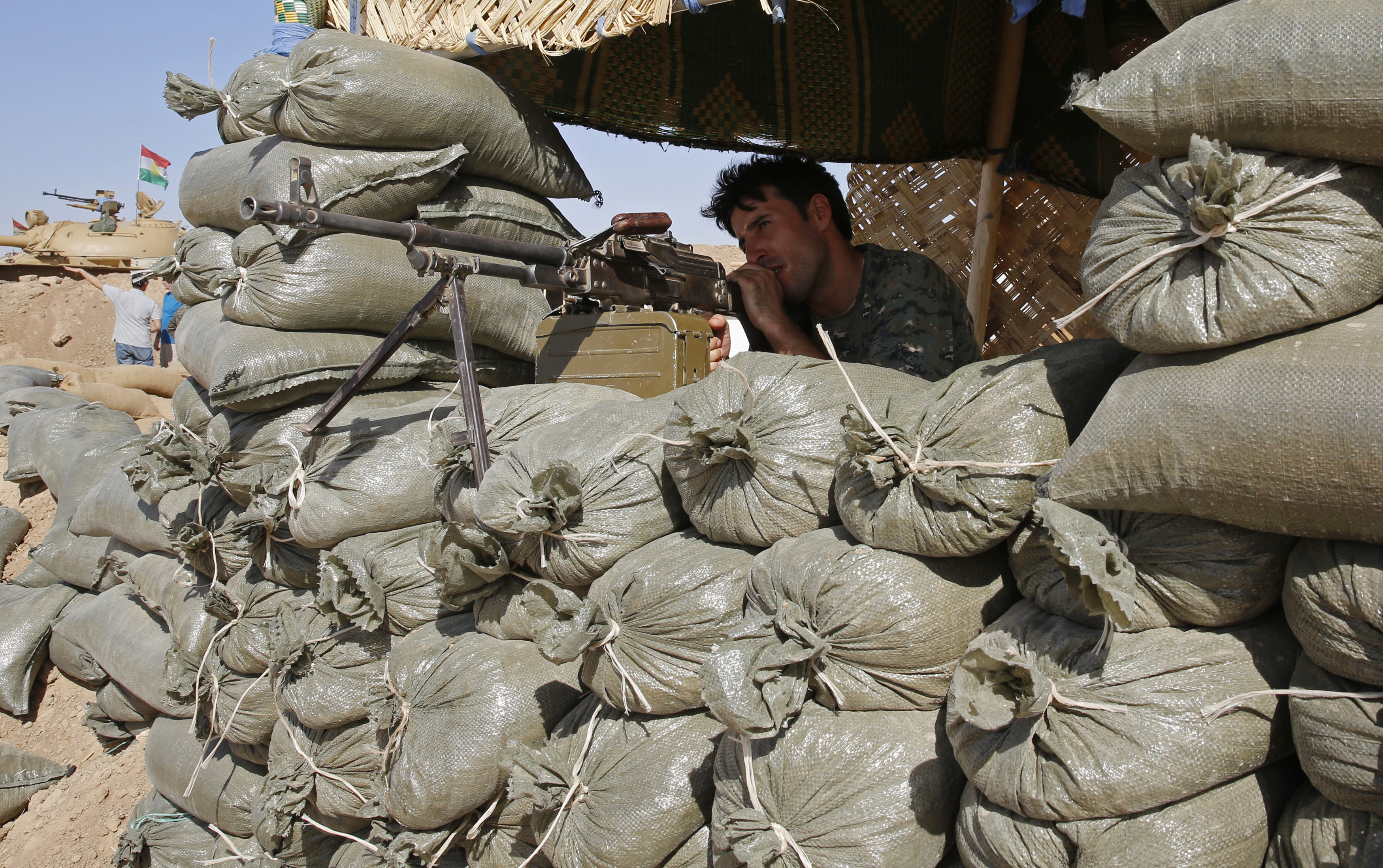 A Kurdish peshmerga fighter takes up position at the front line against the Islamic State, in Khazir