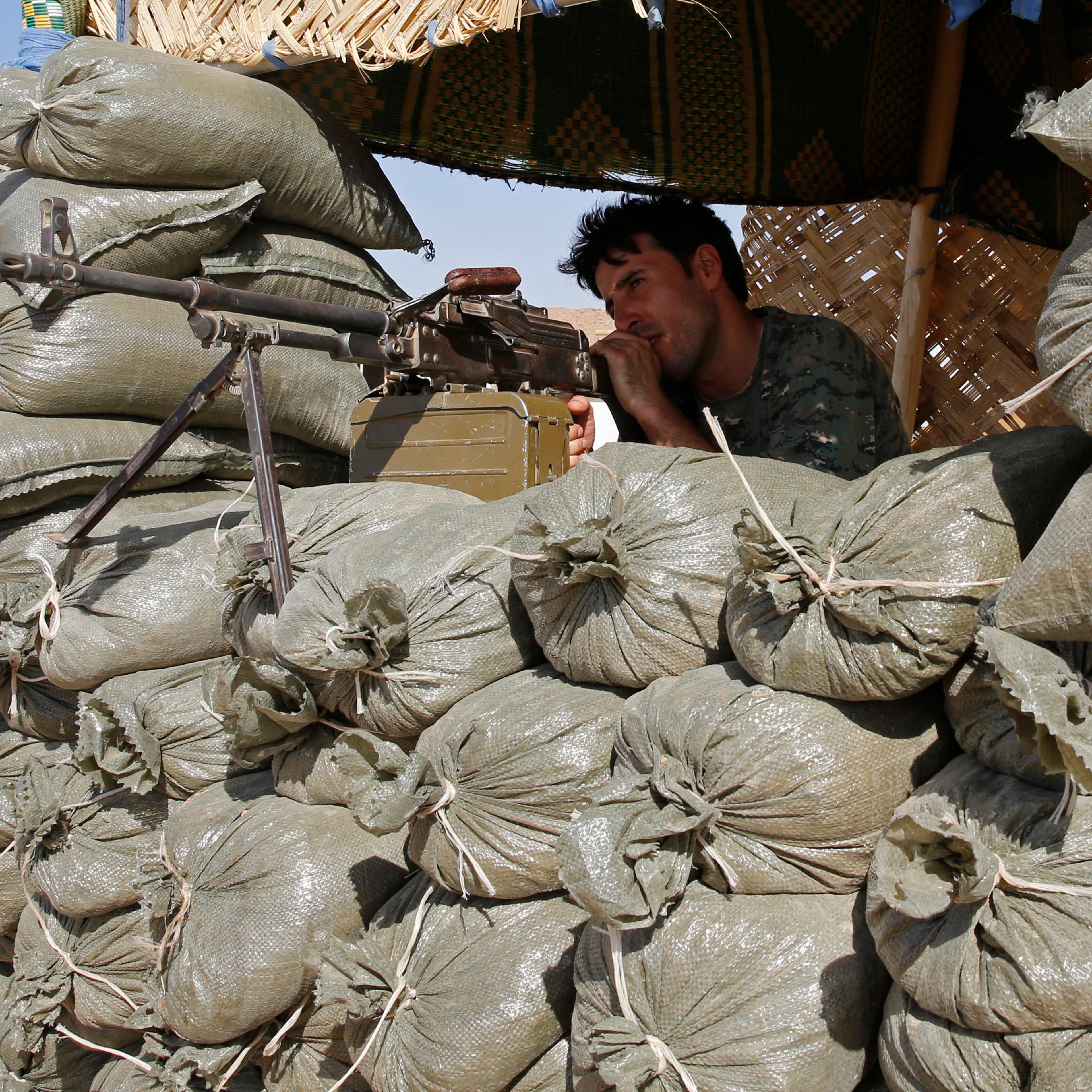 A Kurdish peshmerga fighter takes up position at the front line against the Islamic State, in Khazir