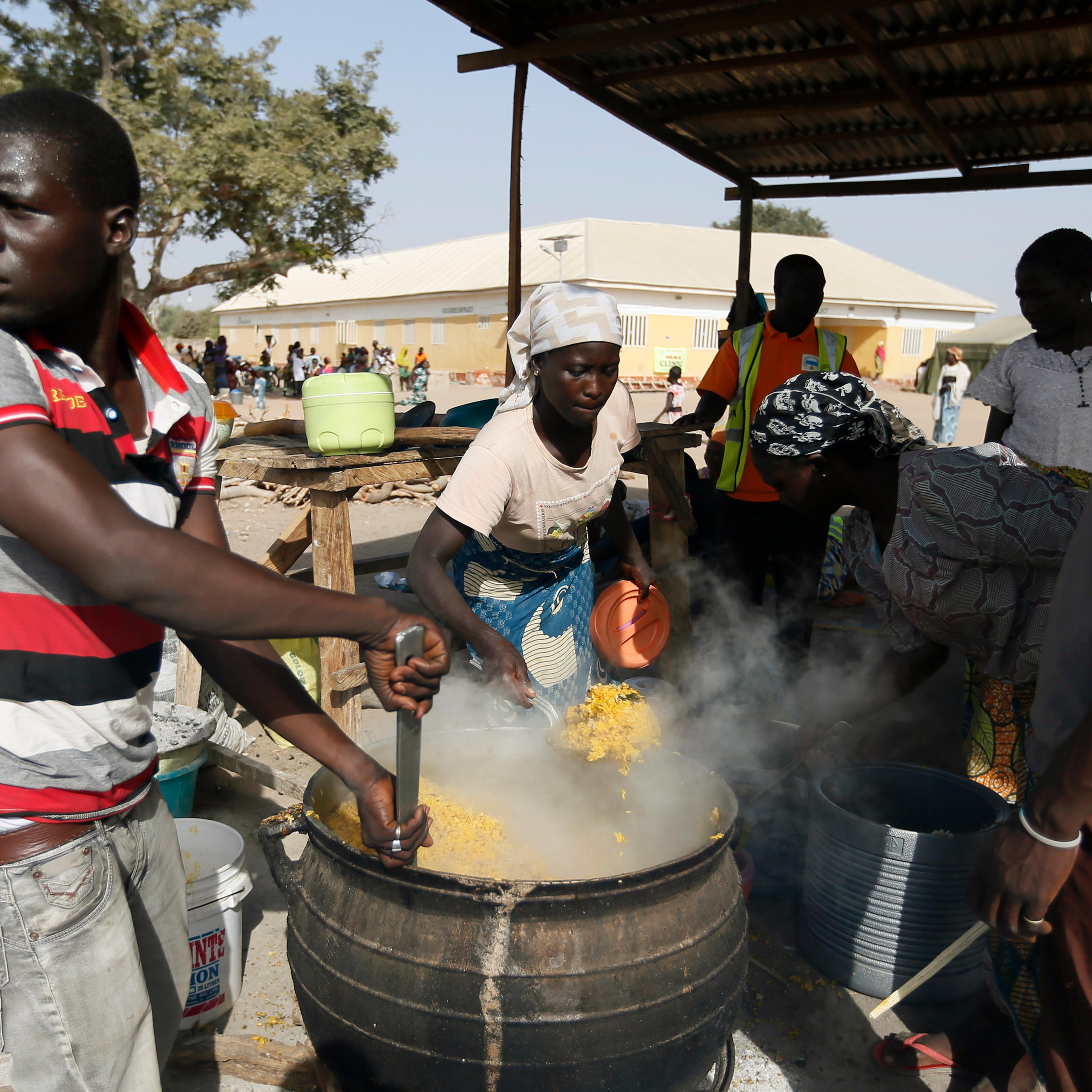 People fleeing Boko Haram violence in the northeast region of Nigeria, cook food at Maikohi secondary school IDP camp in Yola, Adamawa State