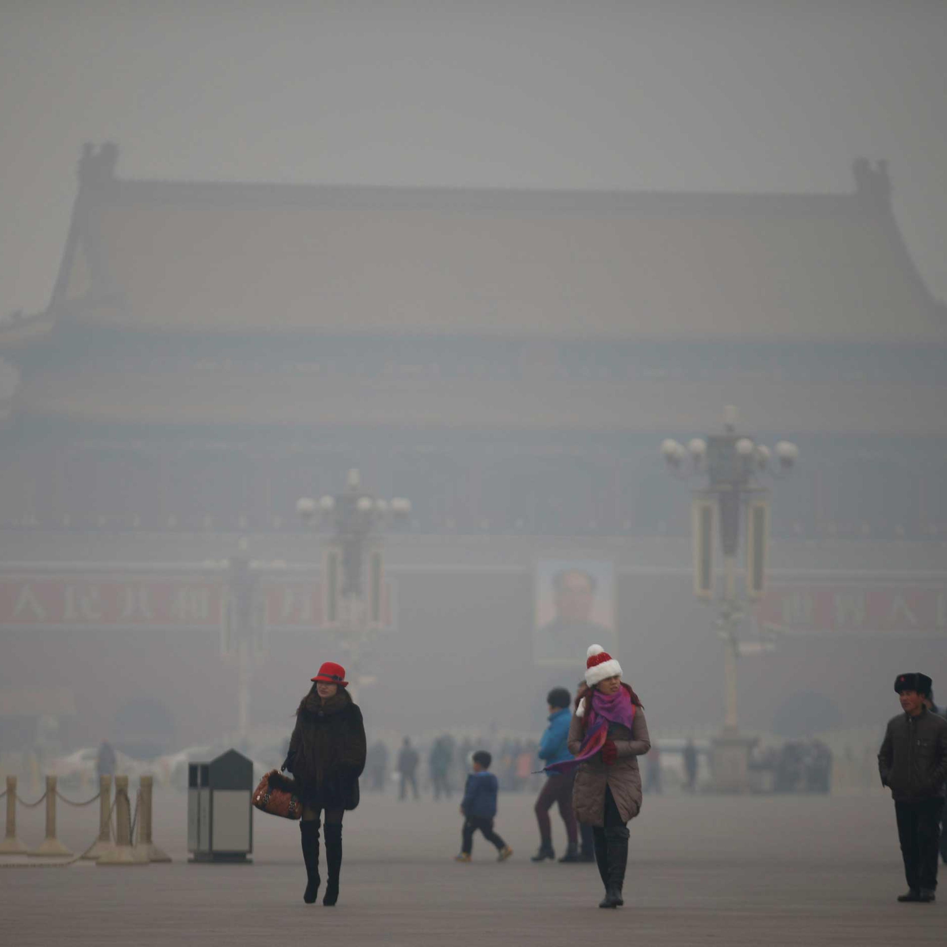 Visitors take a walk during a polluted day at Tiananmen Square in Beijing