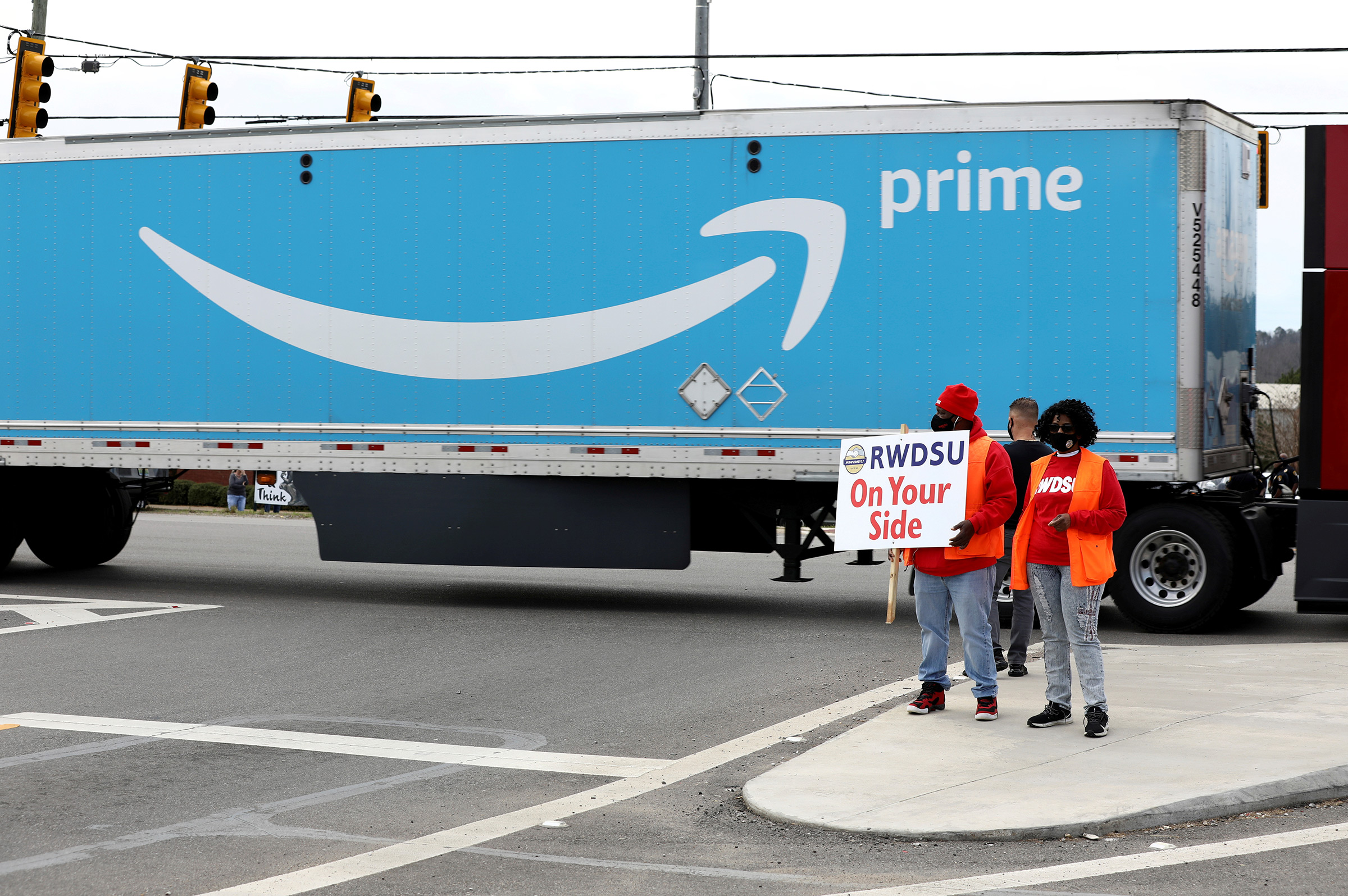 People hold a banner at the Amazon facility as members of a congressional delegation arrive to show their support for workers who will vote on whether to unionize, in Bessemer, Alabama, U.S. March 5, 2021.