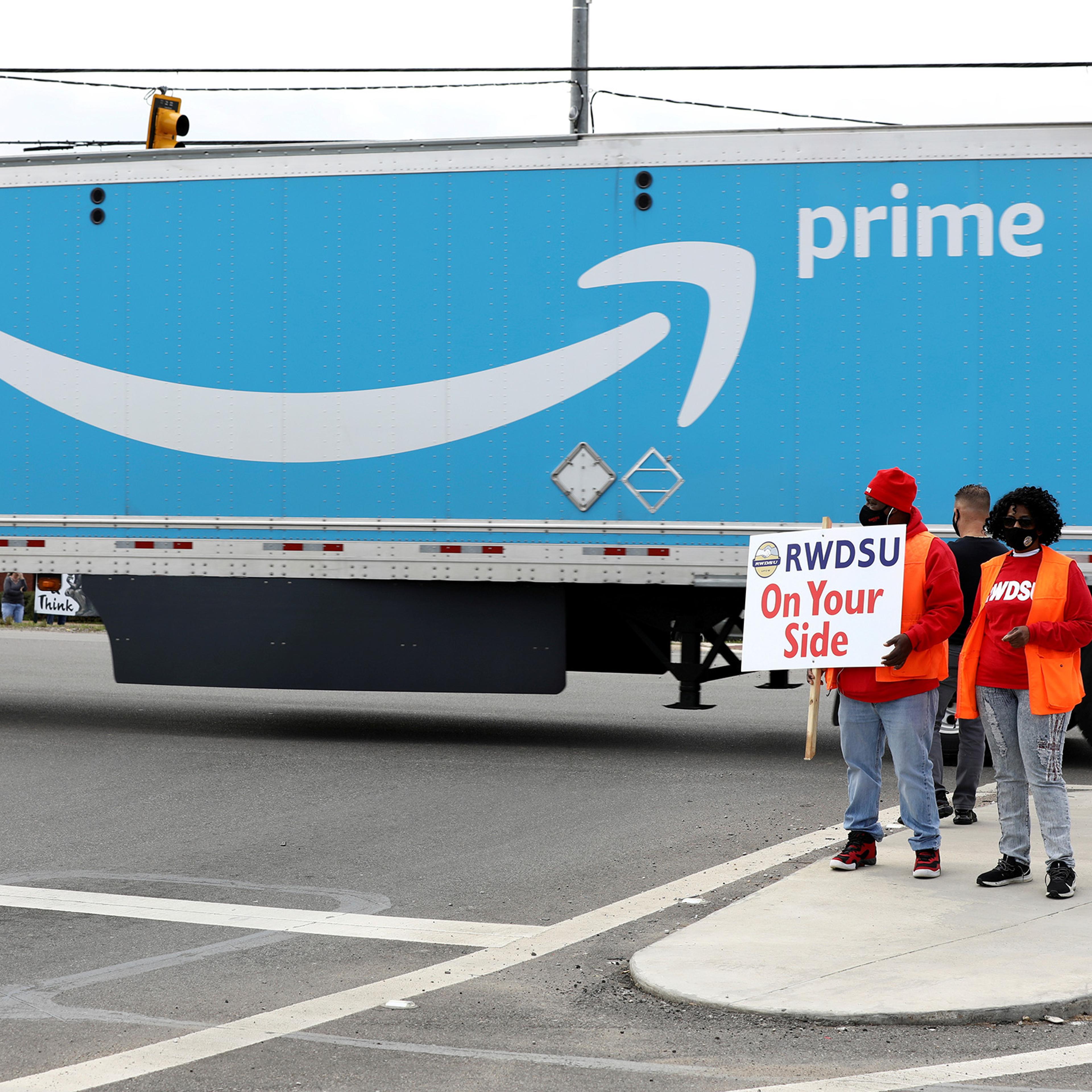 People hold a banner at the Amazon facility as members of a congressional delegation arrive to show their support for workers who will vote on whether to unionize, in Bessemer, Alabama, U.S. March 5, 2021.