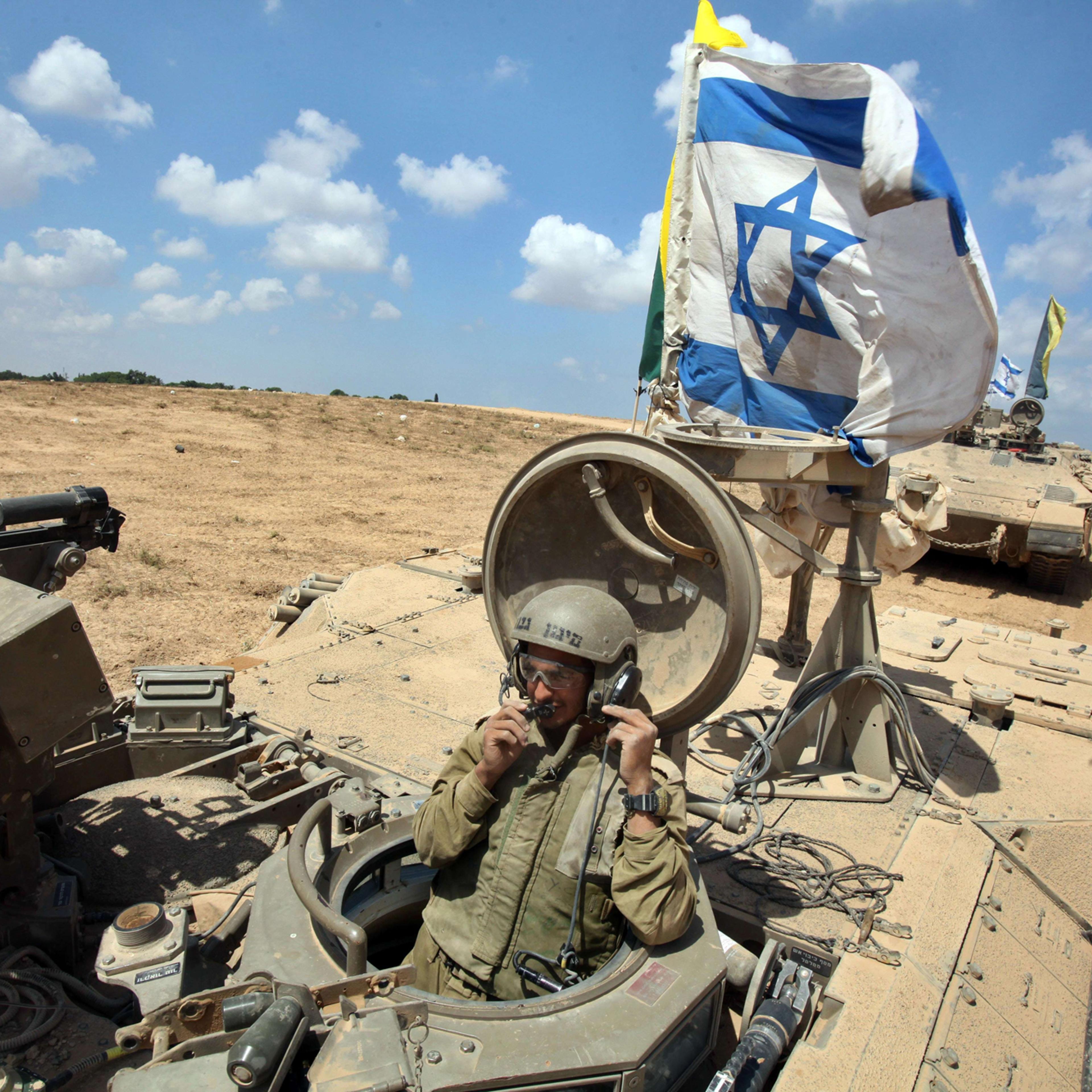 An Israeli soldier sits in an armored personnel carrier flying the Israeli flag as they return from the border between Israel and the Gaza Strip after pulling out of the Palestinian enclave on August 4, 2014 as Israel has begun withdrawing some ground tr