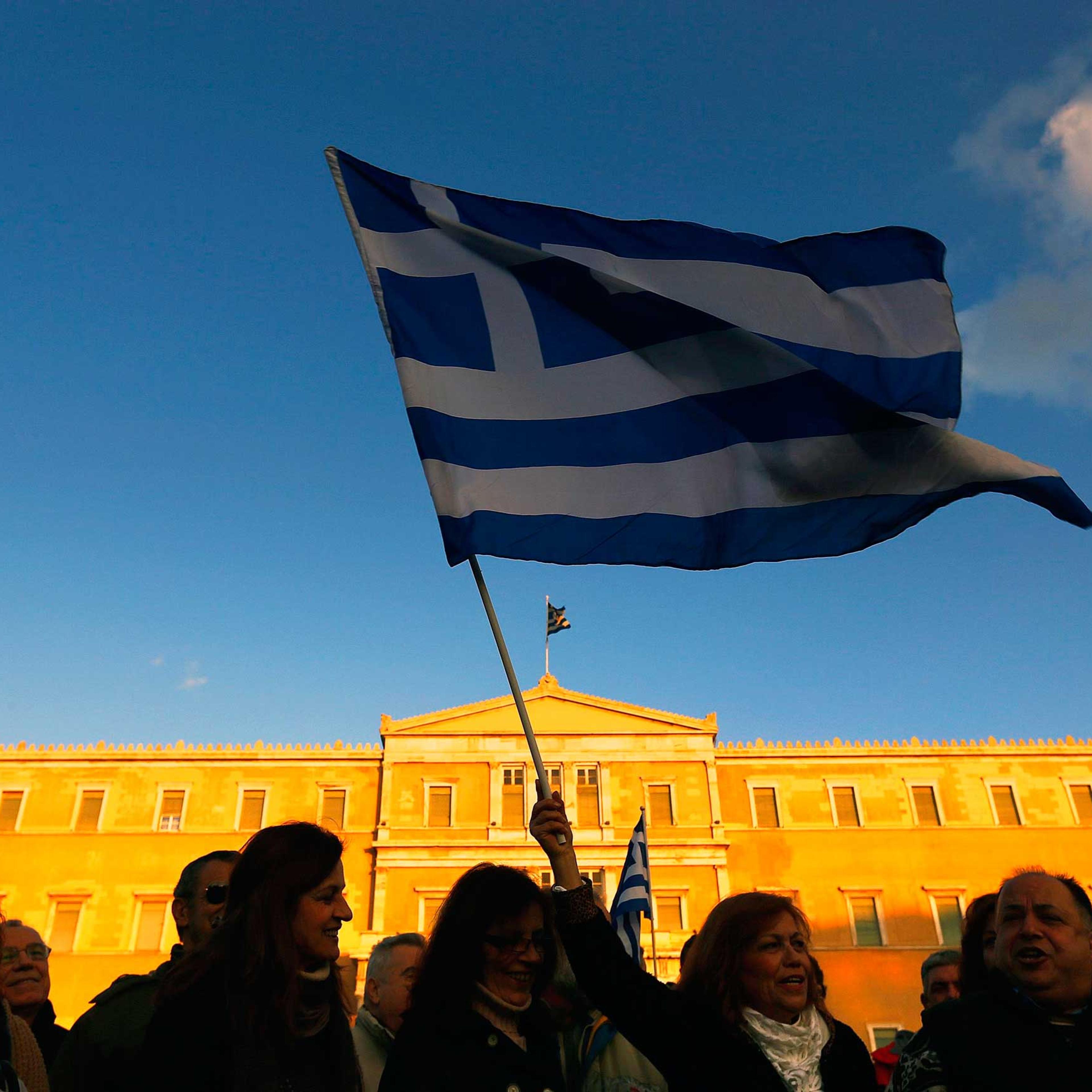 People wave Greek flags in front of the parliament during anti-austerity pro-government demonstration in Athens