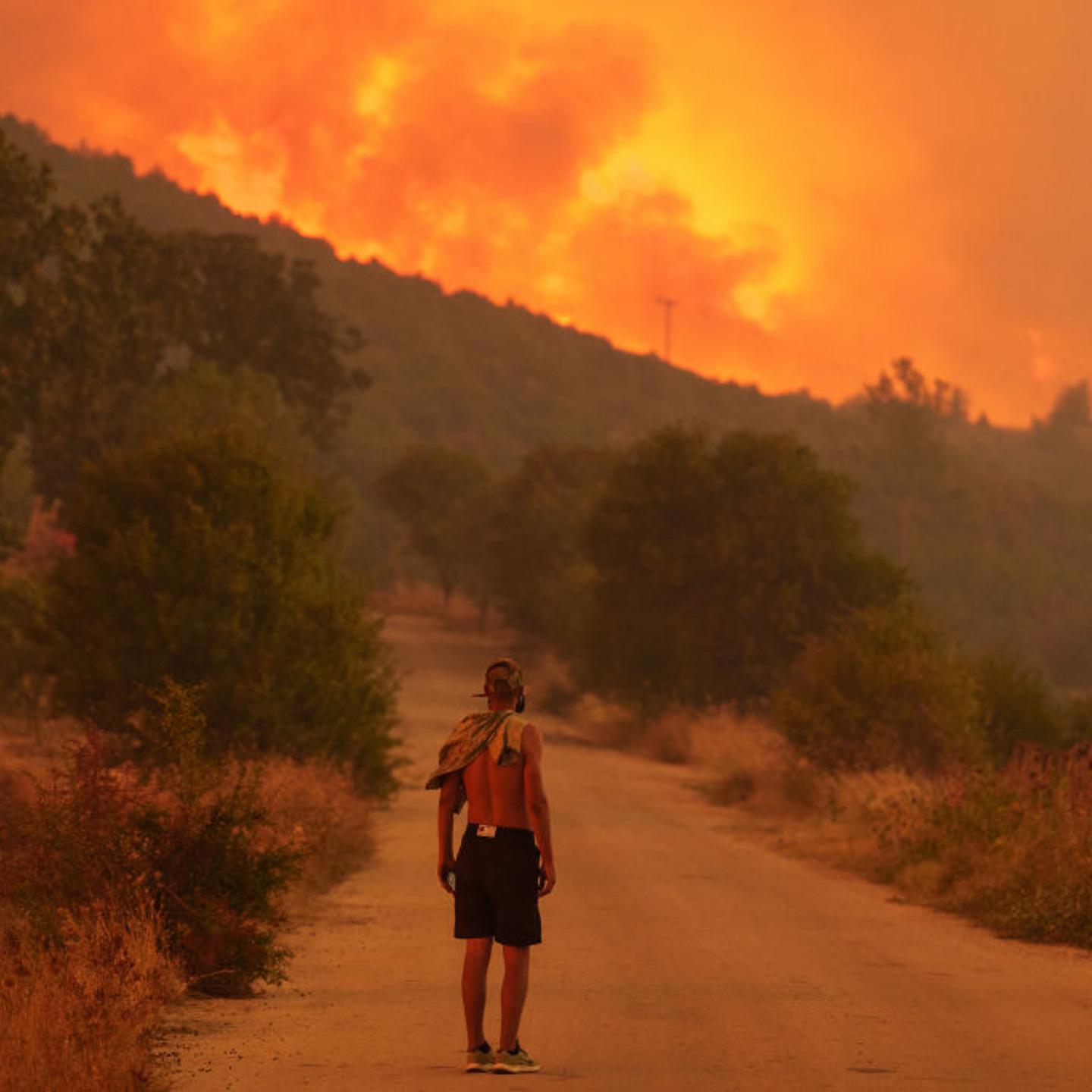 A local resident looks on at the wildfire approaching the village of Avantas, northeast of Alexandroupolis, Greece, on Monday, Aug. 21, 2023.