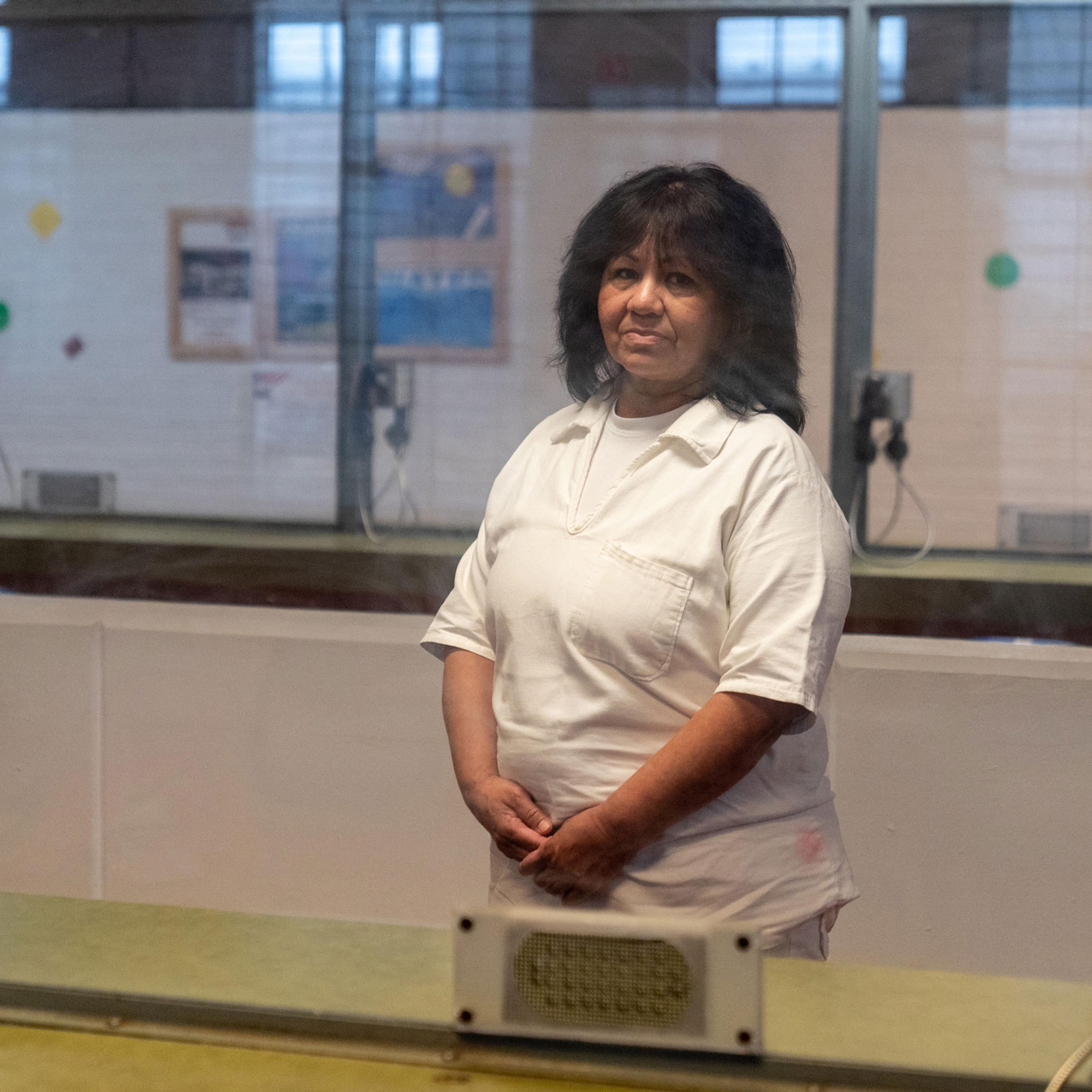 Melissa Lucio poses for a portrait behind glass