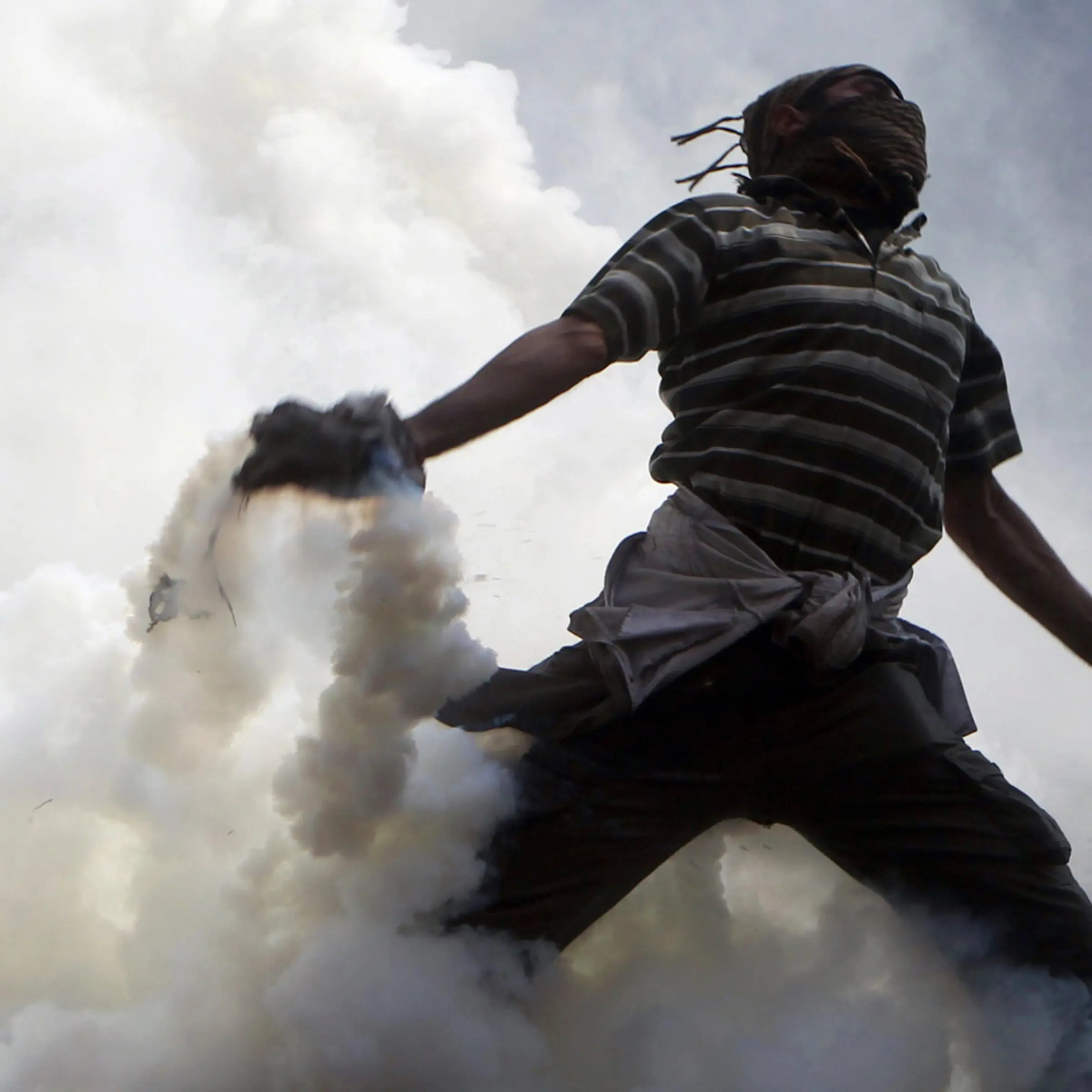 November 22, 2011. A protester tosses a tear gas canister, which was earlier thrown by riot police during clashes along a road which leads to the Interior Ministry, near Tahrir Square in Cairo. Egyptians frustrated with military rule battled police in the streets again on Nov. 22 as generals scrambled to cope with the cabinet's proffered resignation after bloodshed that has jolted plans for Egypt's first free election in decades.