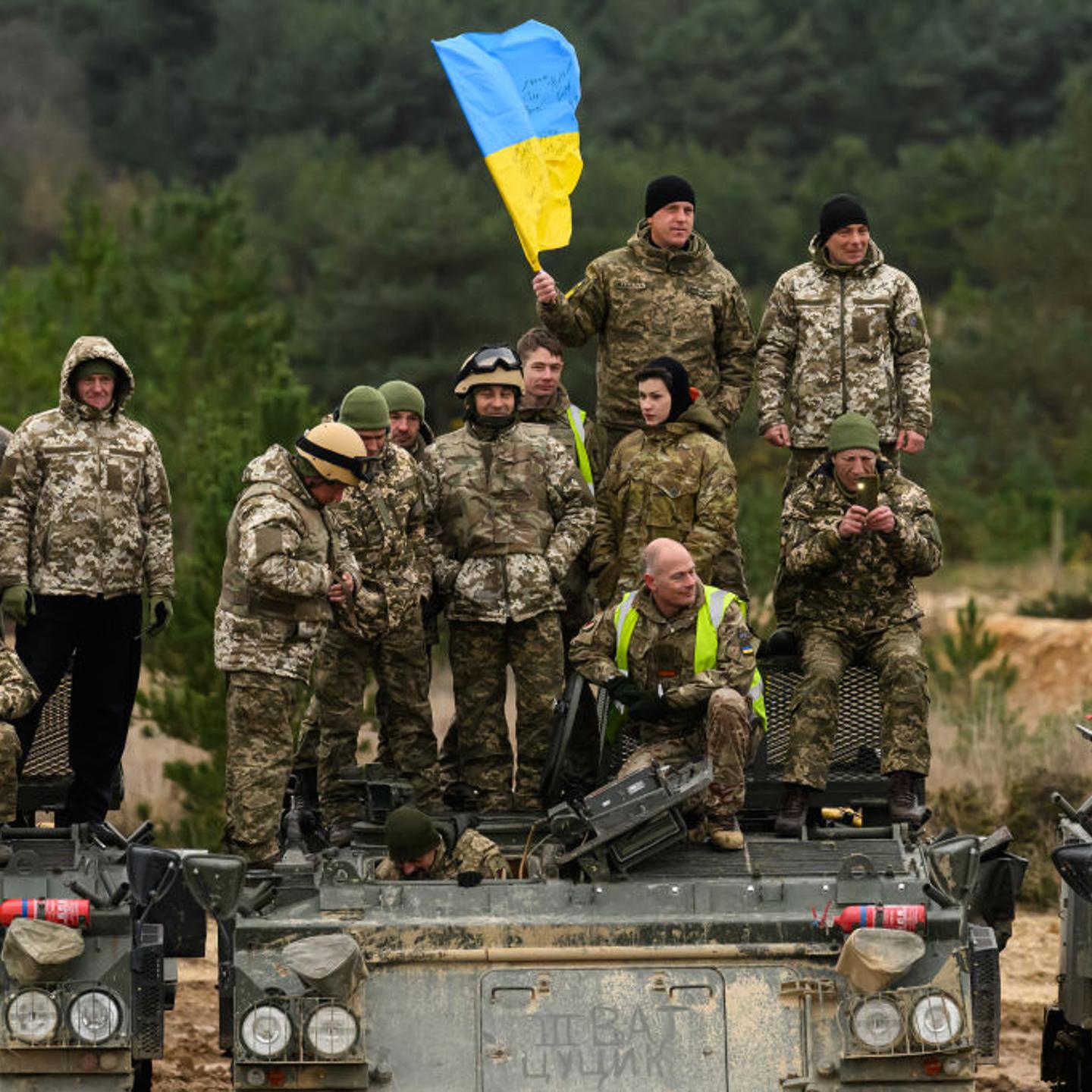 Ukrainian recruits and their British Armed Forces trainers pose for a photograph on Driver Tank Trainer (DTT) armoured vehicles at a military facility, on Feb. 23, 2023 in Southern England.