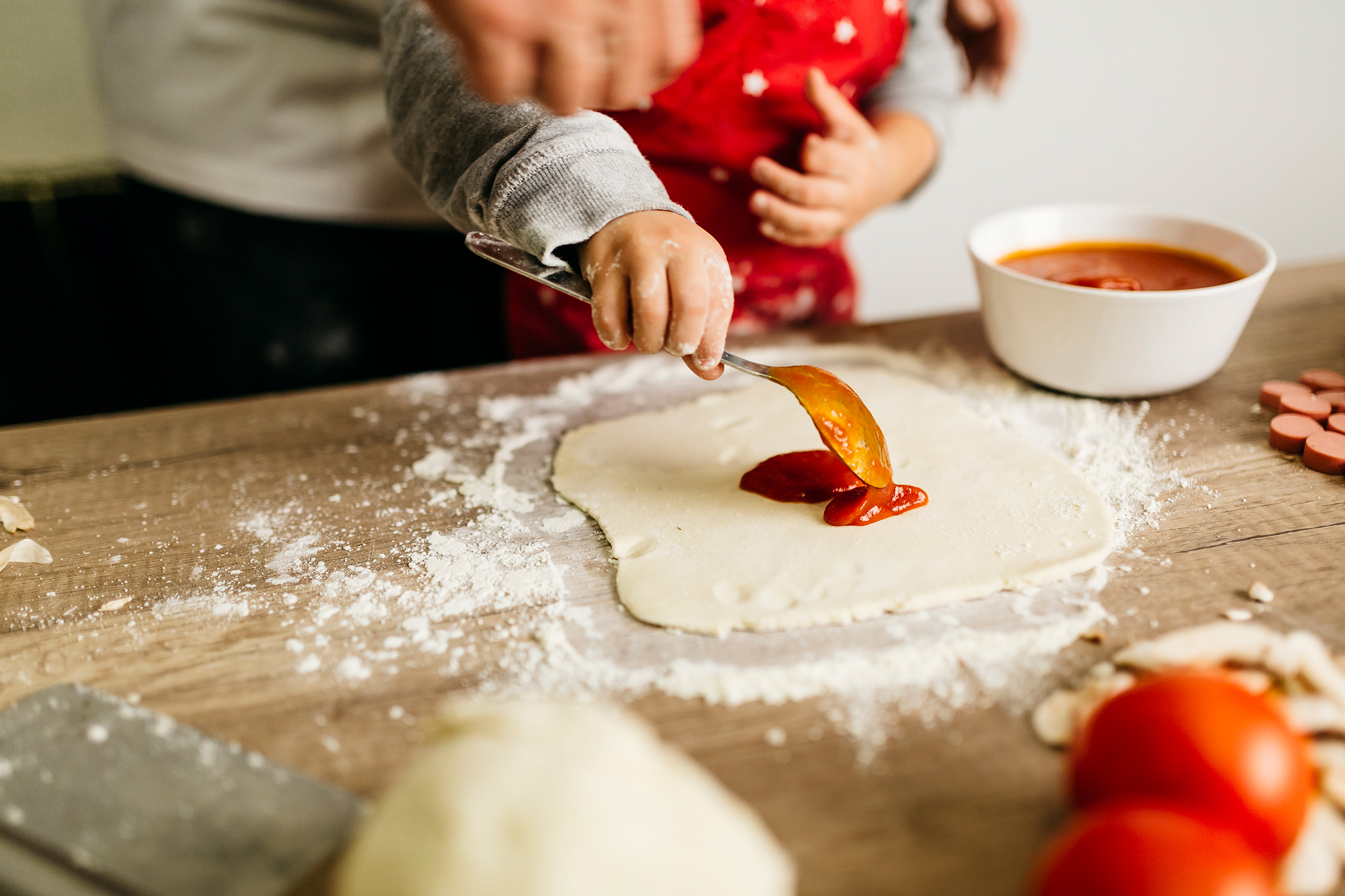 Father and son preparing pizza together