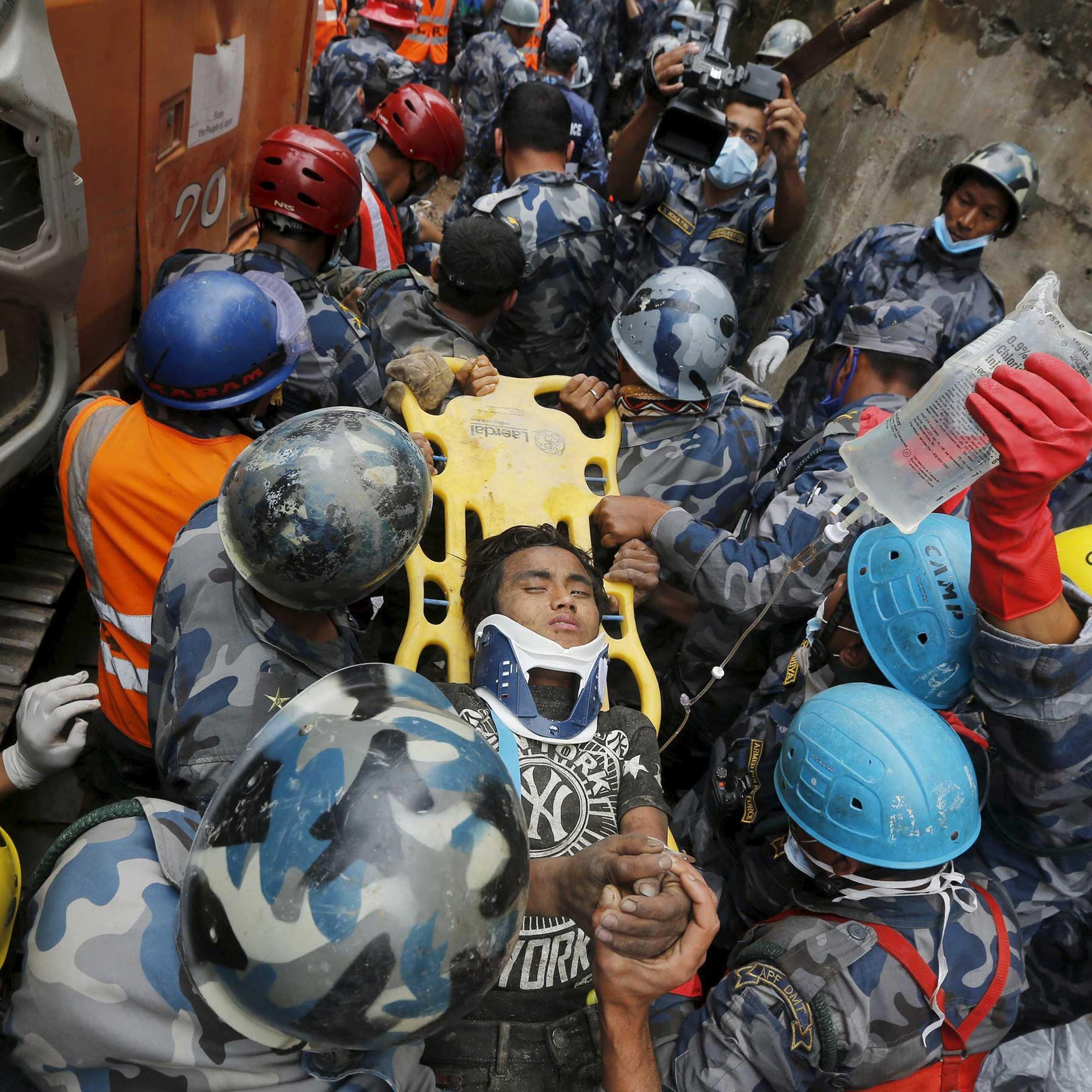 Earthquake survivor Pema Lama, 15, is rescued by the Armed Police Force from the collapsed Hilton Hotel, the result of an earthquake in Kathmandu, Nepal on April 30, 2015.