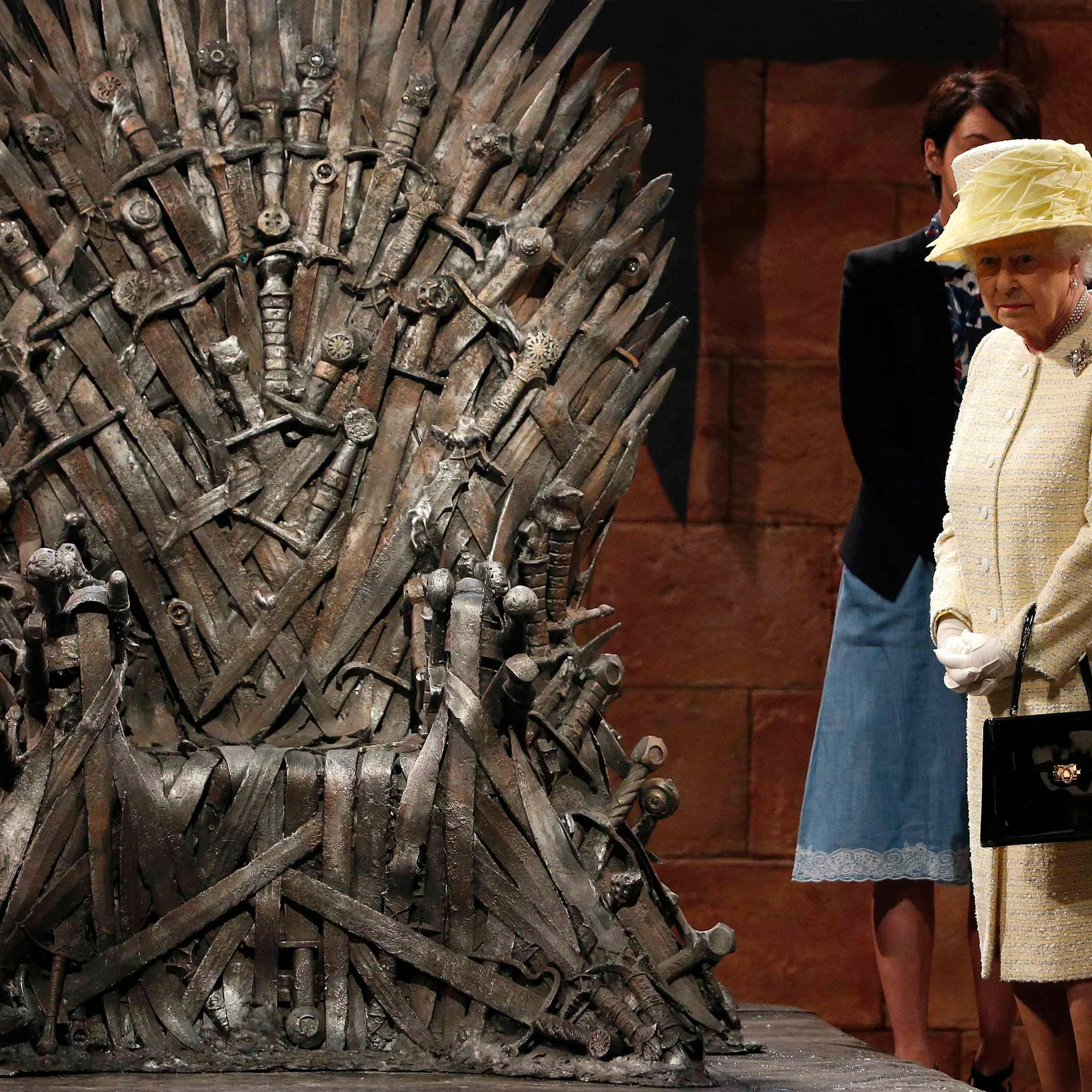 Britain's Queen Elizabeth looks at the Iron Throne as she meets members of the cast on the set of the television show Game of Thrones in the Titanic Quarter of Belfast, Northern Ireland, June 24, 2014.