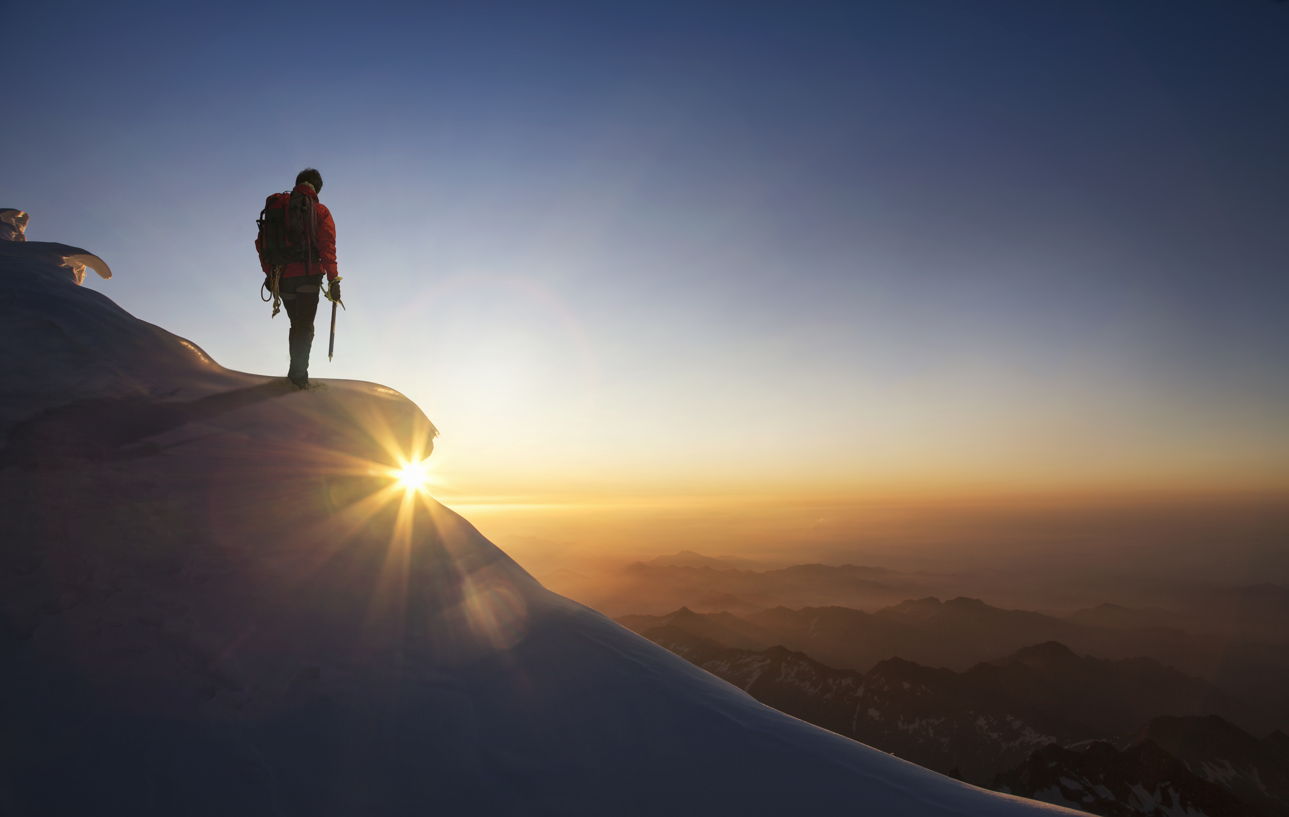 man-standing-mountain-top-sunrise