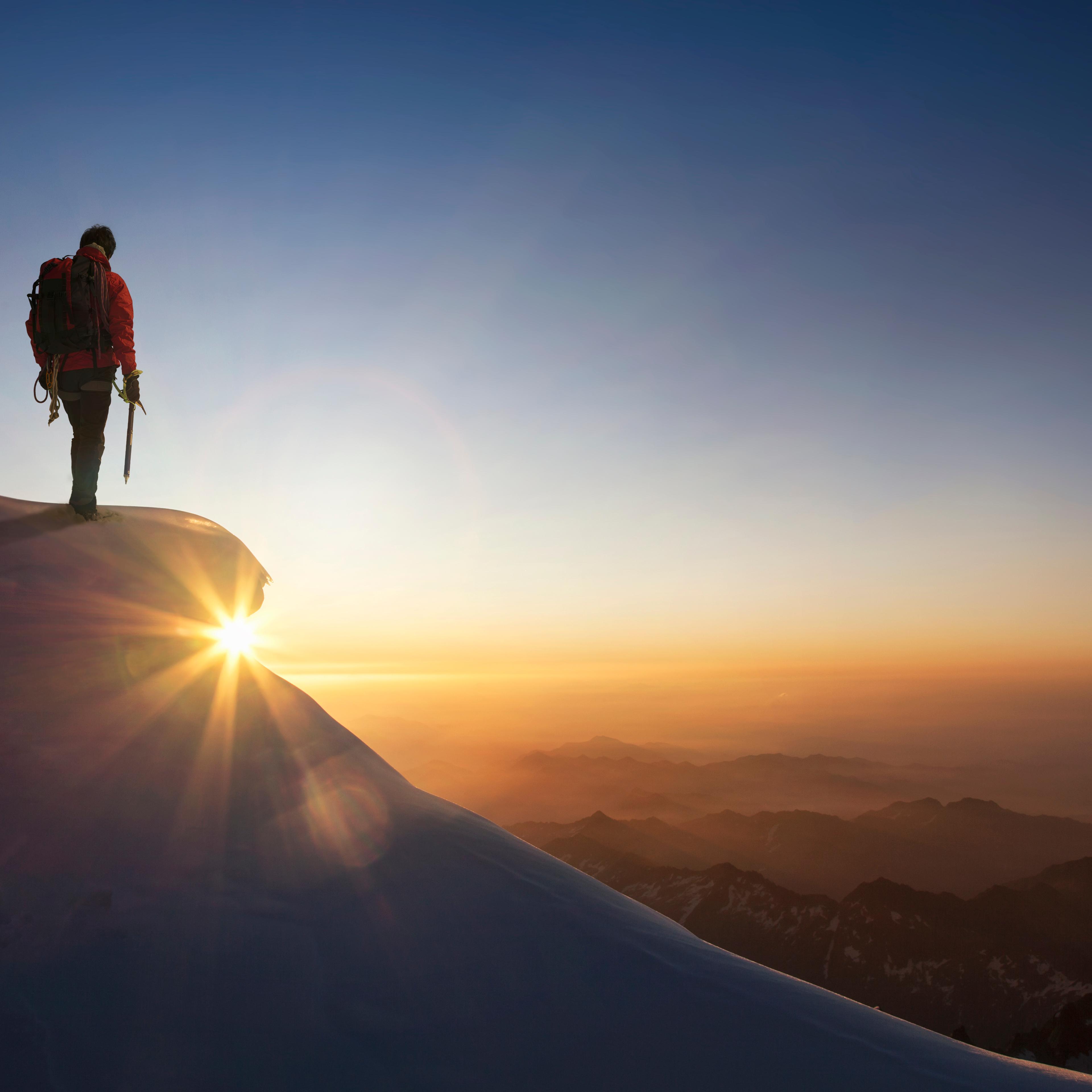 man-standing-mountain-top-sunrise
