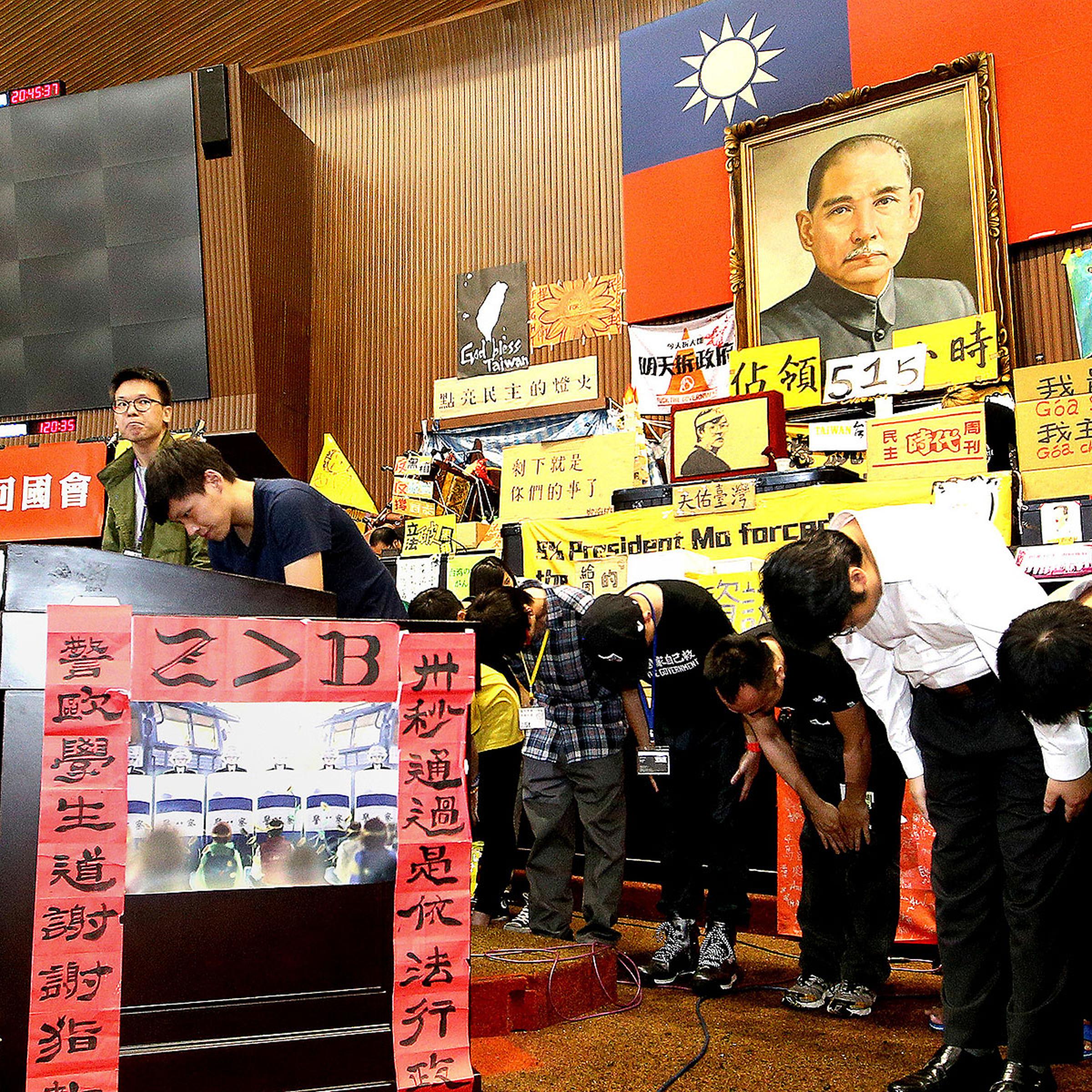 Student leaders bow to supporters during a news conference at Taiwan's legislative Yuan, the island's parliament, in Taipei on April 7, 2014