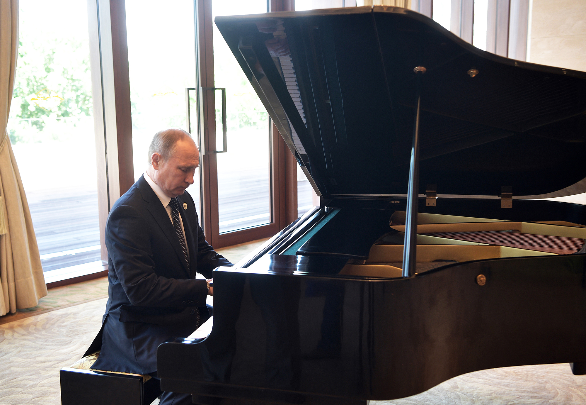 Russian President Vladimir Putin plays piano before his talks with Chinese President Xi Jinping prior to the opening ceremony of the Belt and Road Forum in Beijing, on May 14, 2017.