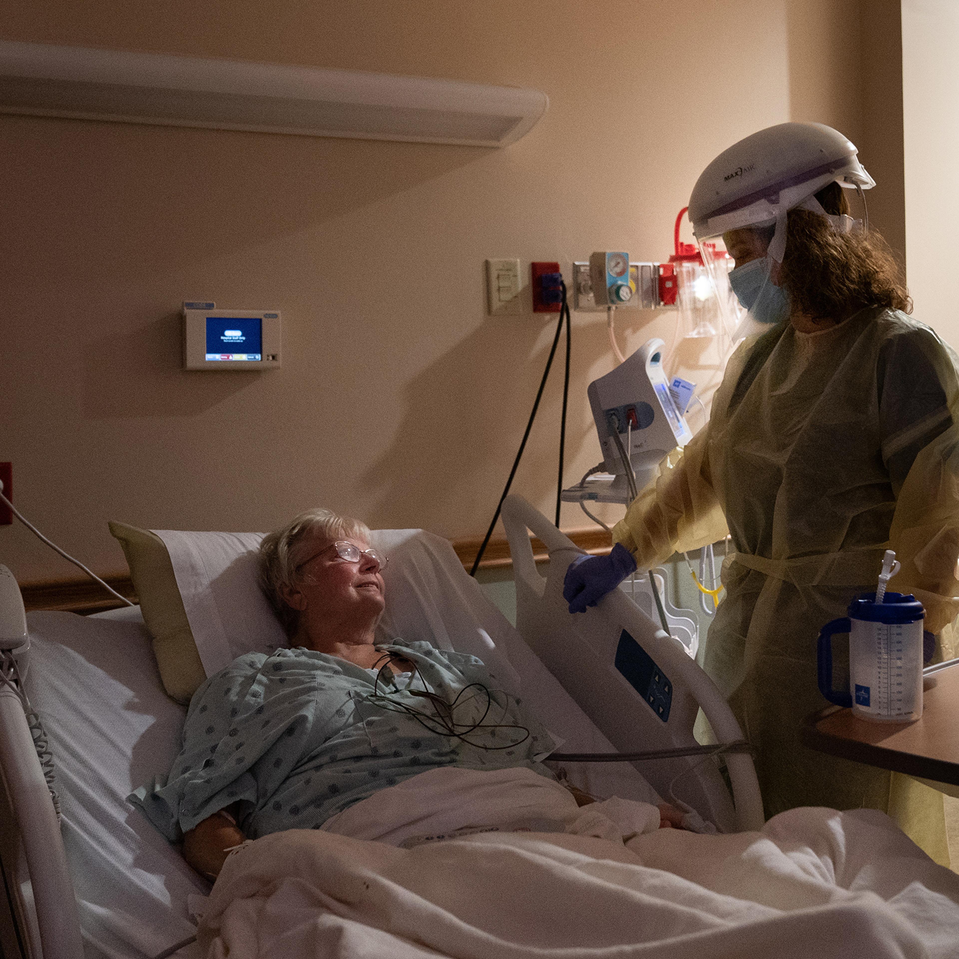 Dr. Rebecca Martin talks with Barbara Billigmeier, a patient hospitalized with COVID-19, at Baxter Regional Medical Center in Mountain Home, Ark., on July 8, 2021. Despite her ordeal, Billigmeier said, she hasn't changed her mind about getting vaccinated