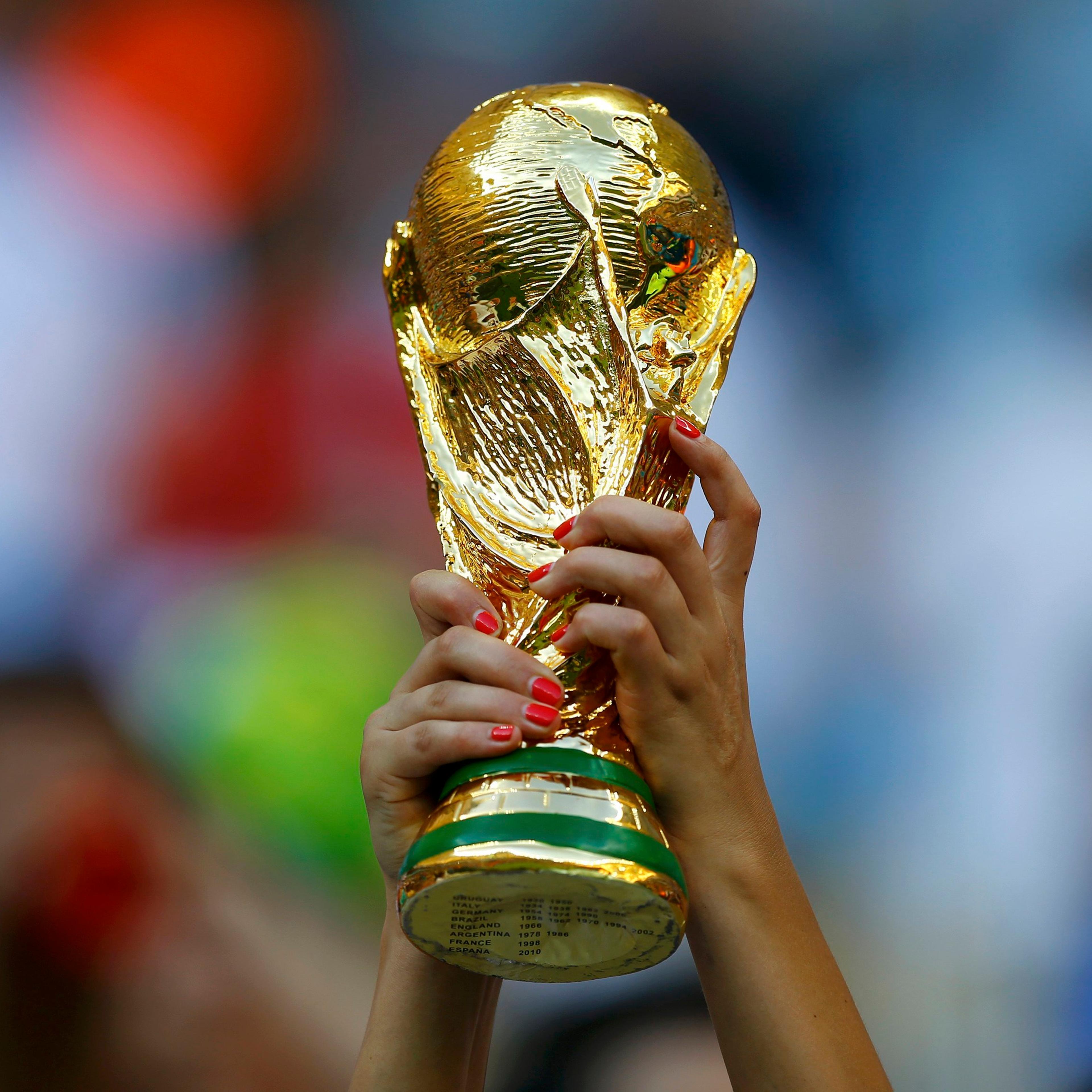 A fan holds up a trophy before the 2014 World Cup Group D soccer match between England and Italy at the Amazonia arena in Manaus on June 14, 2014.