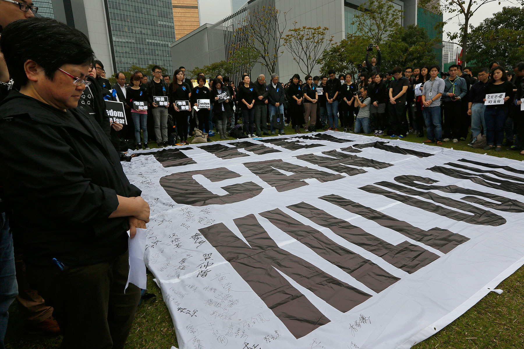 Journalists and their supporters stand in a five minutes silent around a huge banner reads " They can't kill us all " during a rally outside the government headquarter in Hong Kong, March 2, 2014