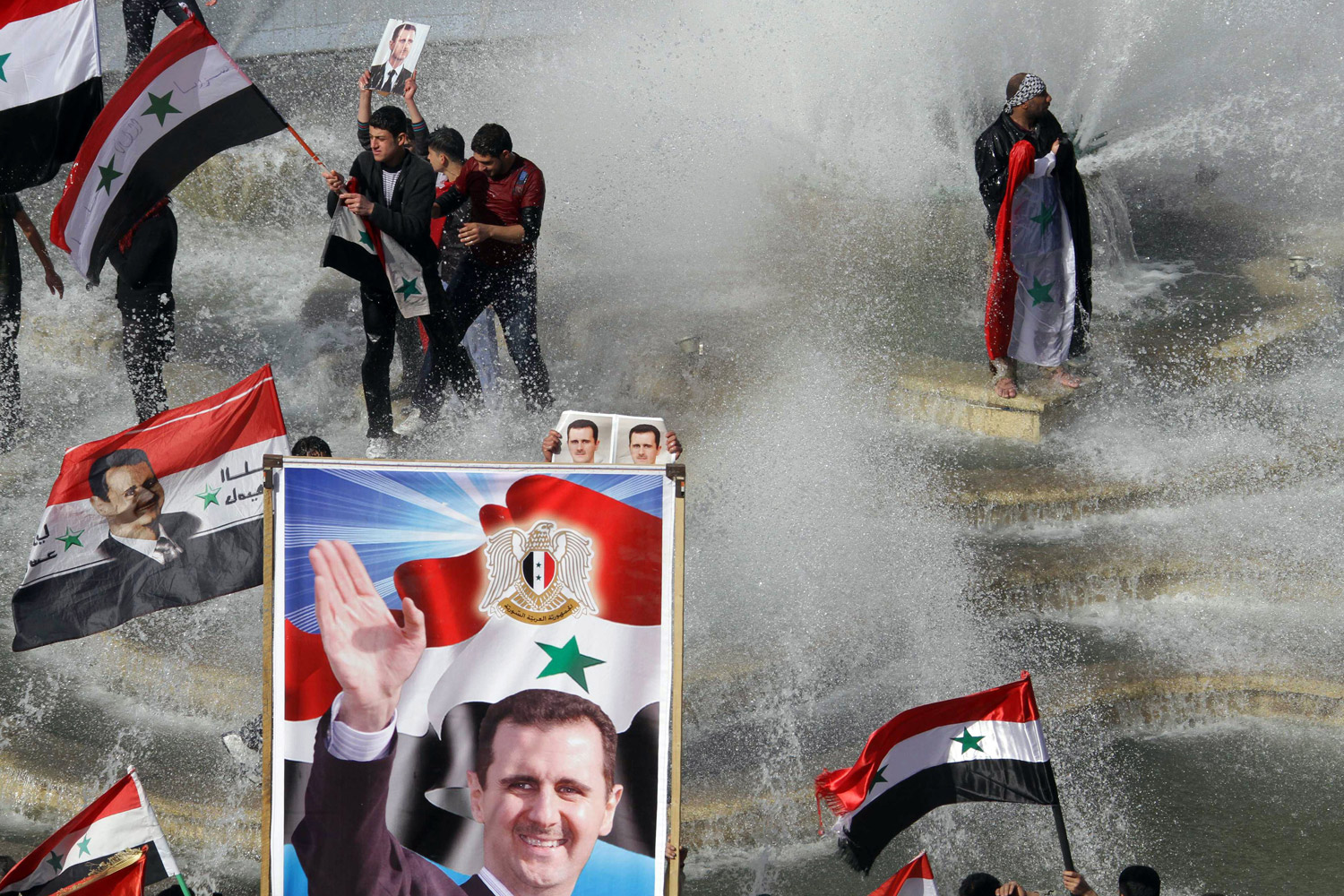November 13, 2011. Syrians take to a fountain with their national flag to show support for President Bashar Assad after the Arab League suspended Syria because of its treatment of protesters. 

