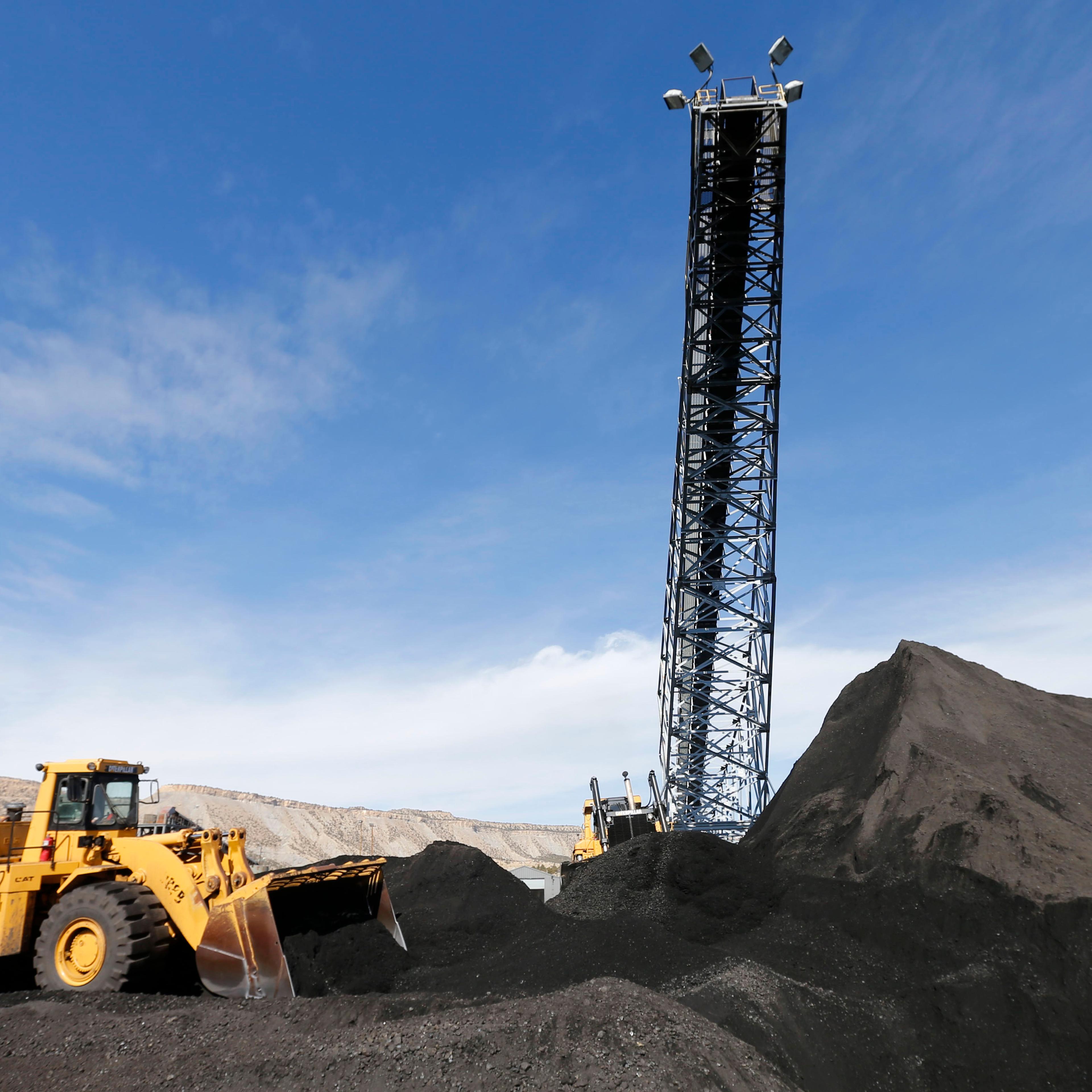 Two Caterpillar earth movers move piles of coal at the Wildcat Coal Load-Out Terminal, owned by Intermountain Power Agency, outside Price, Utah on March 5, 2014.