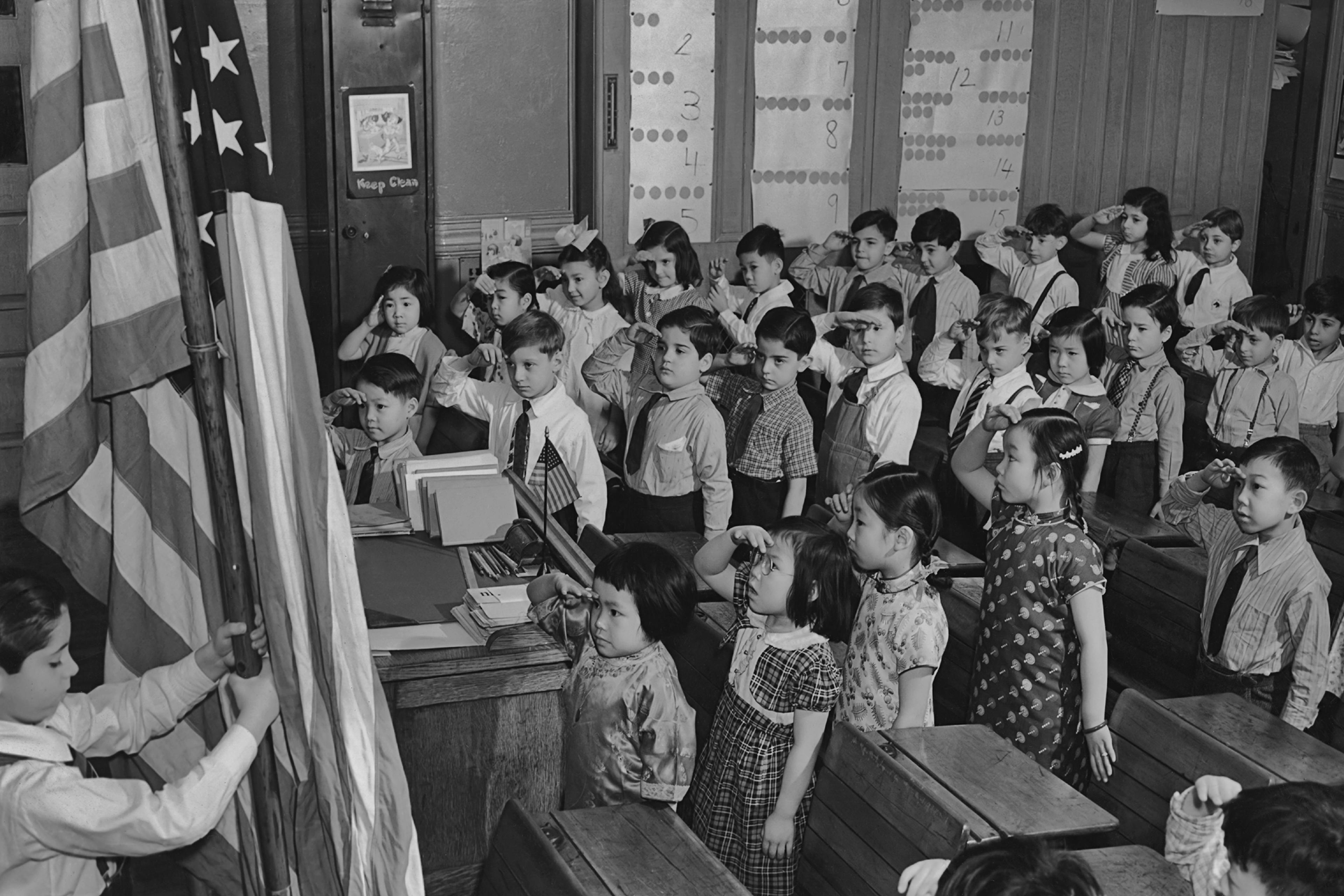 A group of children saluting the American flag at a school in the Chinatown area of Manhattan circa 1960.