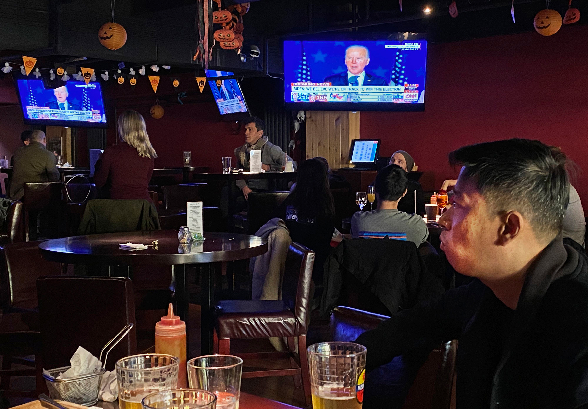 Customers watch television during an election watching event at a local bar on Nov. 4 in Beijing