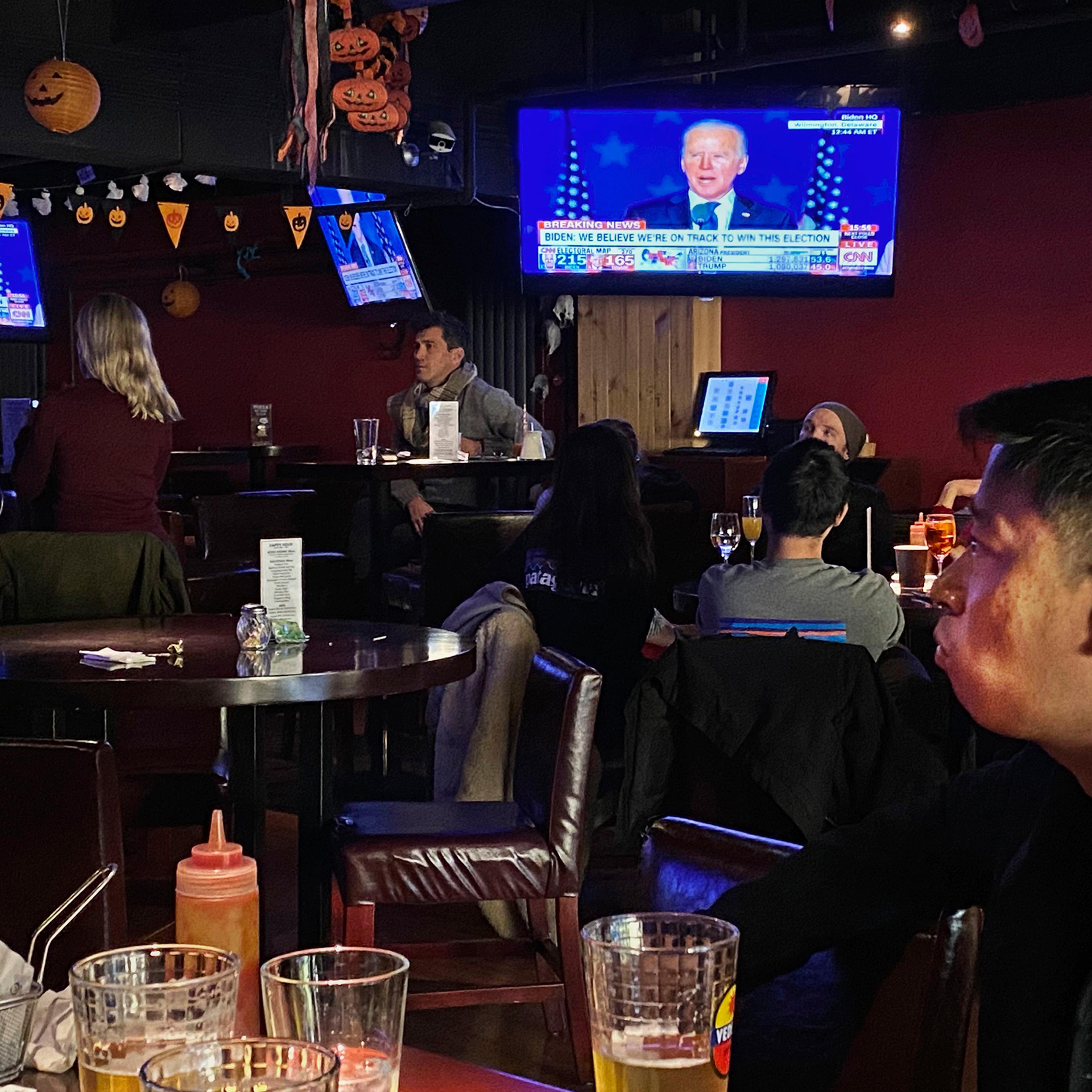 Customers watch television during an election watching event at a local bar on Nov. 4 in Beijing