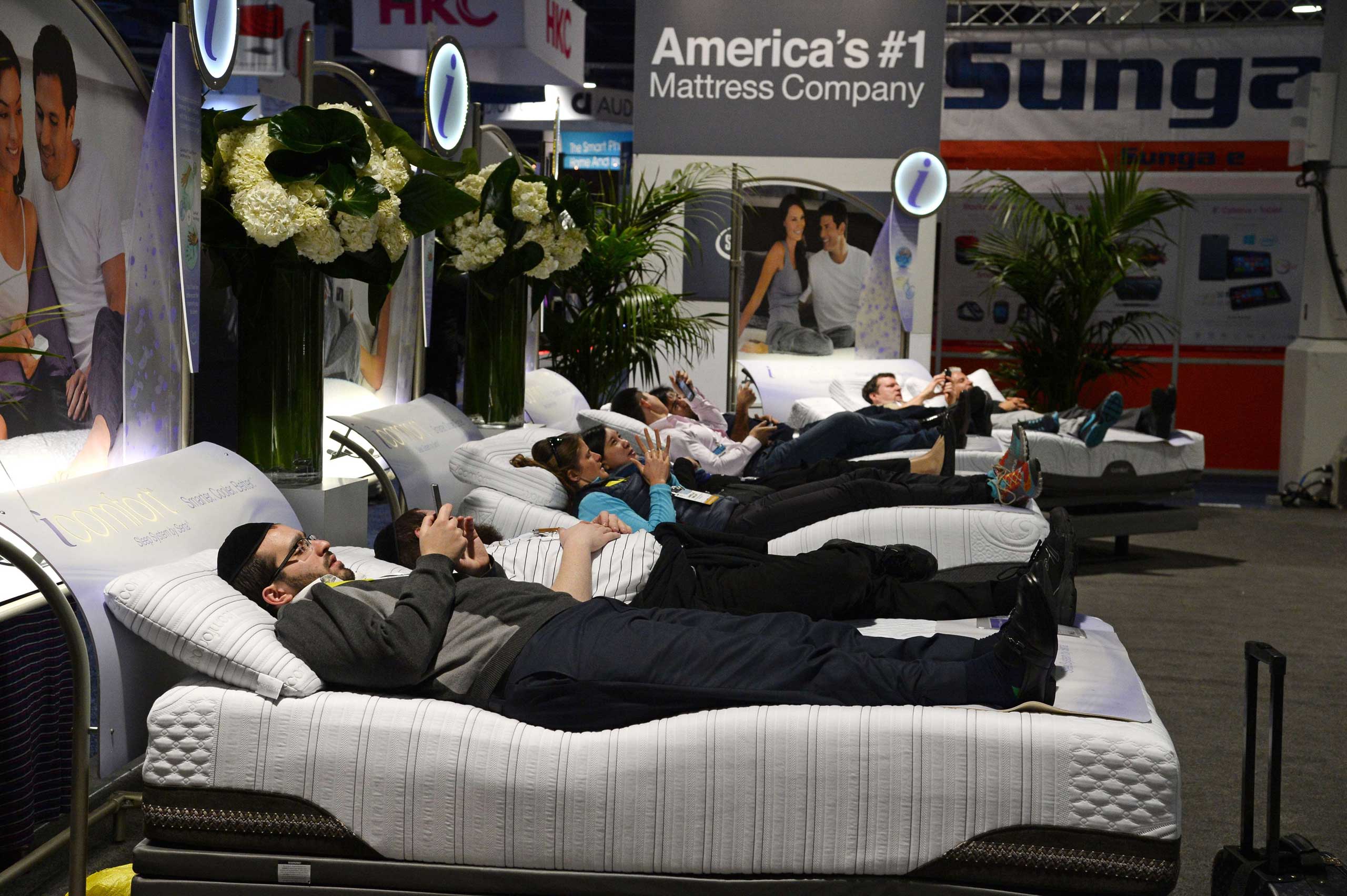 Attendees lay on Serta mattresses at the Serta stand on Jan. 6, 2015 at the Consumer Electronics Show in Las Vegas.