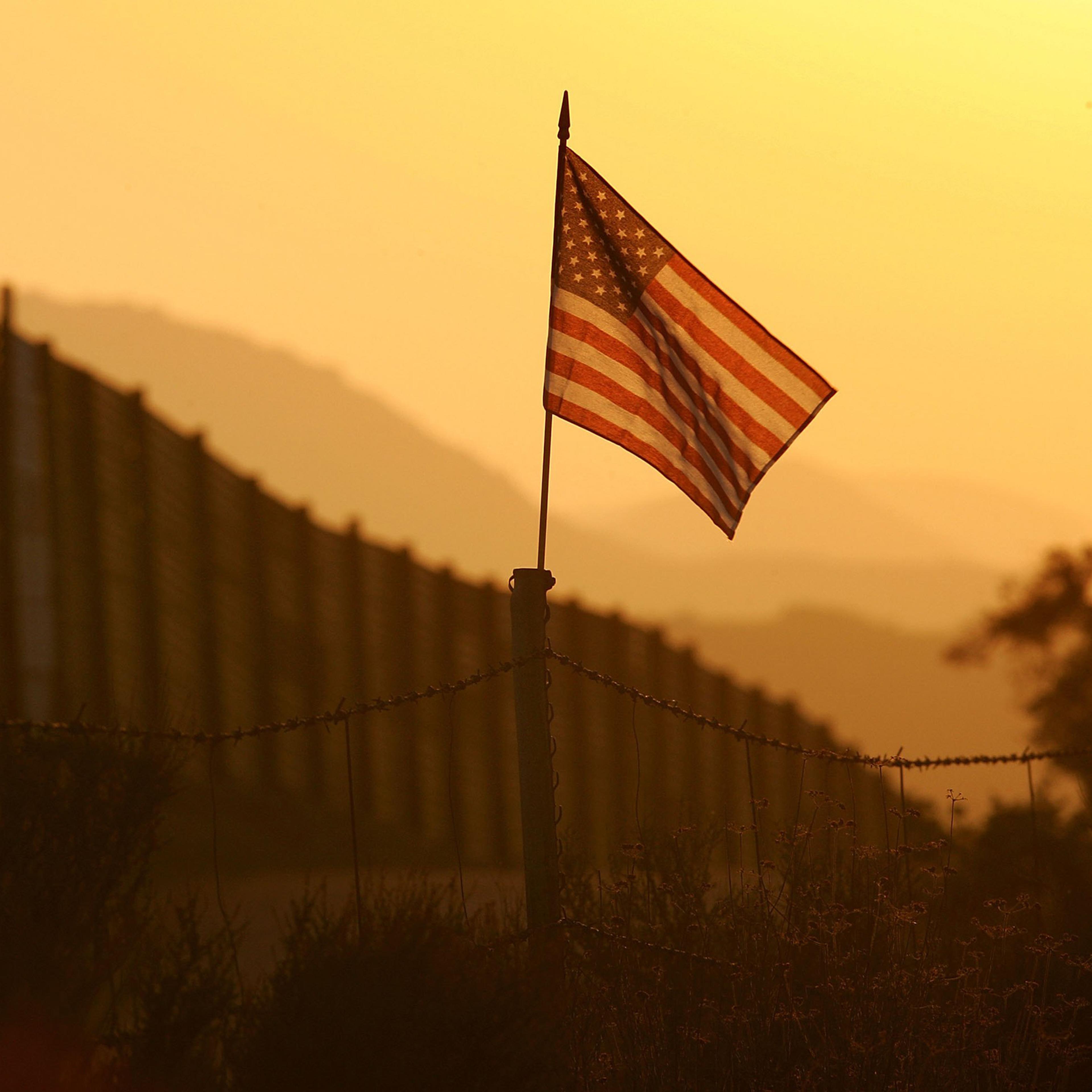 A U.S. flag put up by activists who oppose illegal immigration flies near the US-Mexico border fence near Campo, California, on Oct. 8, 2006.