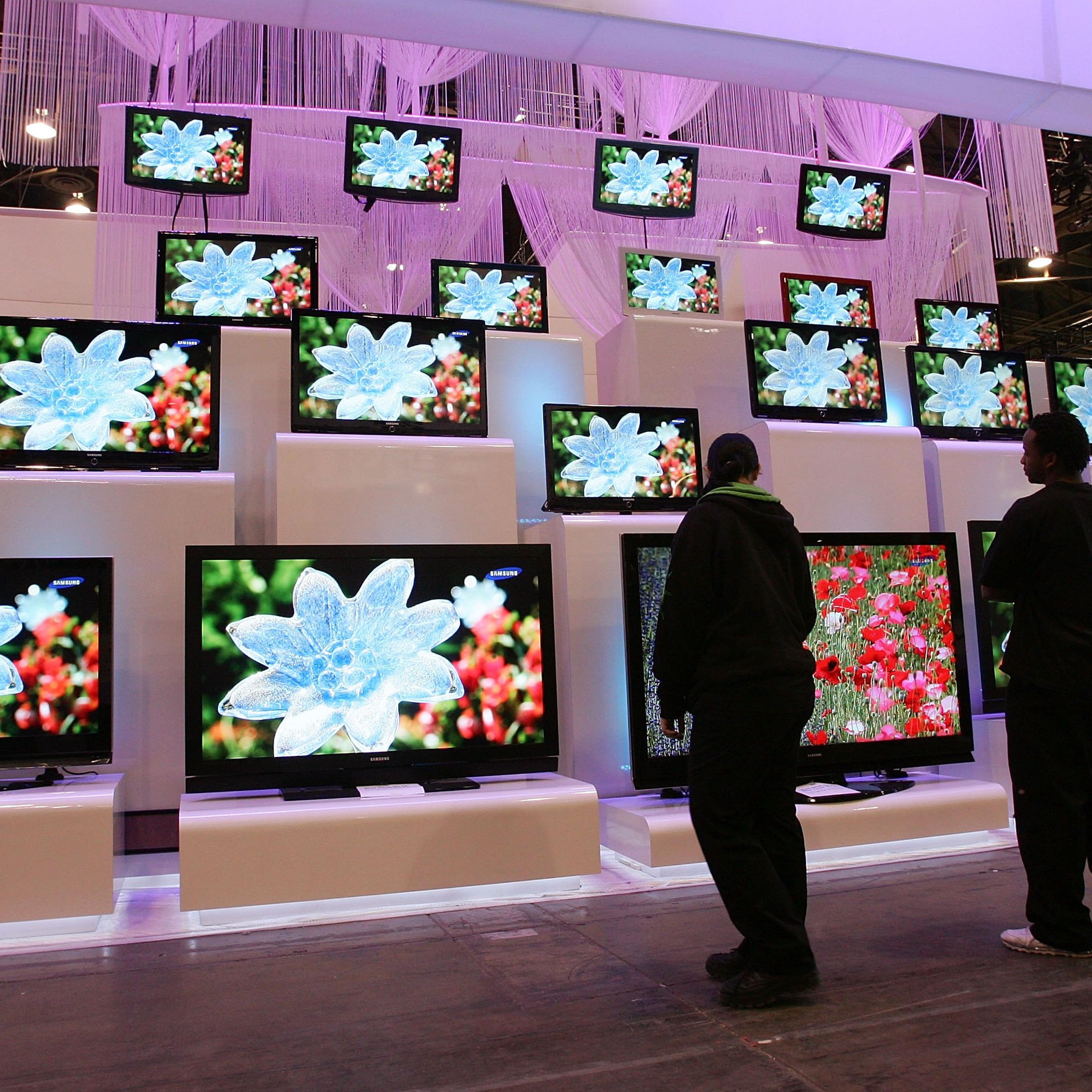 Workers look at a display of televisions by Samsung at the Las Vegas Convention Center as preparations continue for the opening of the 2007 International Consumer Electronics Show January 5, 2007 in Las Vegas, Nevada.
