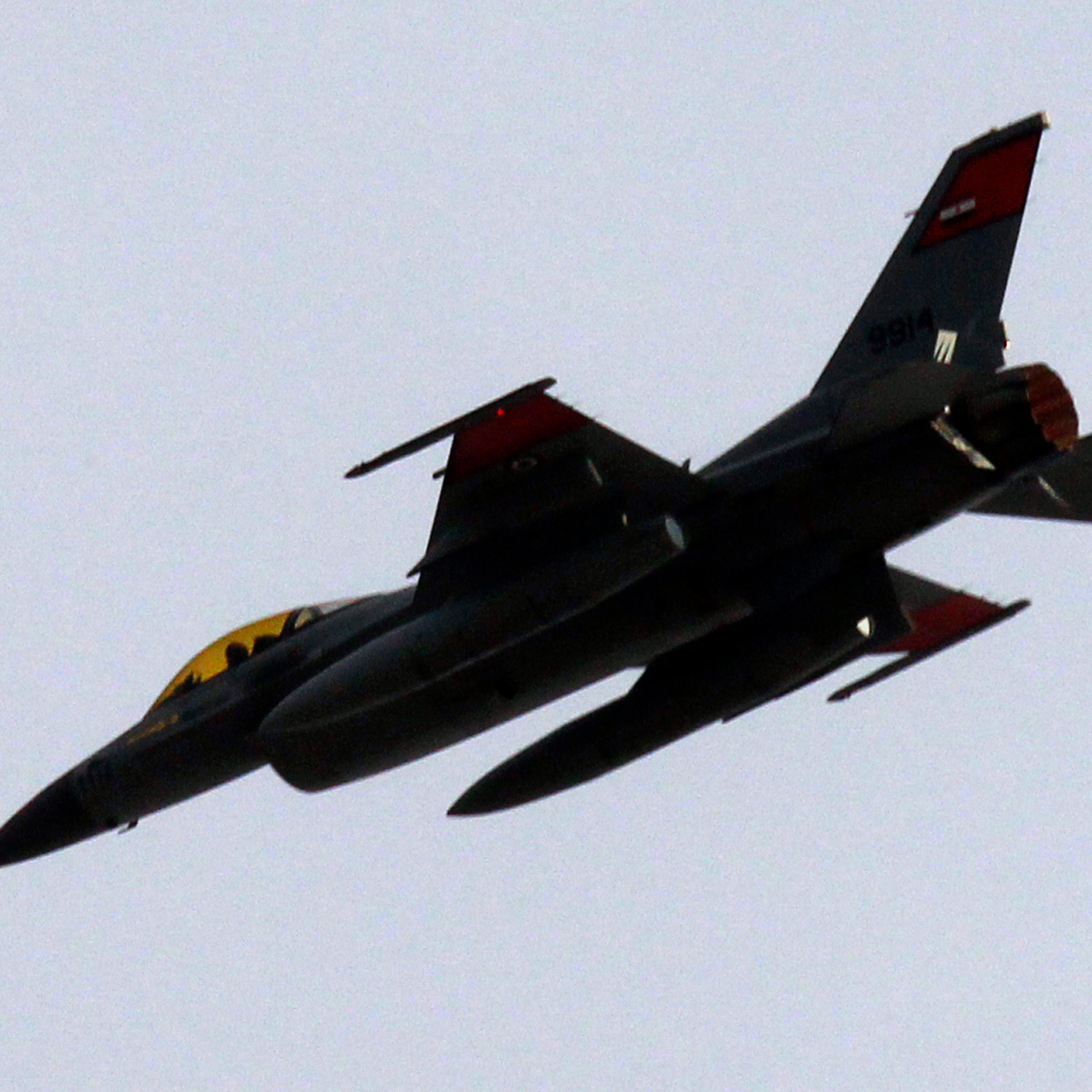 An Egyptian Air Force F-16 fighter jet flies low over thousands of anti-government protesters gathered at Tahrir square in Cairo
