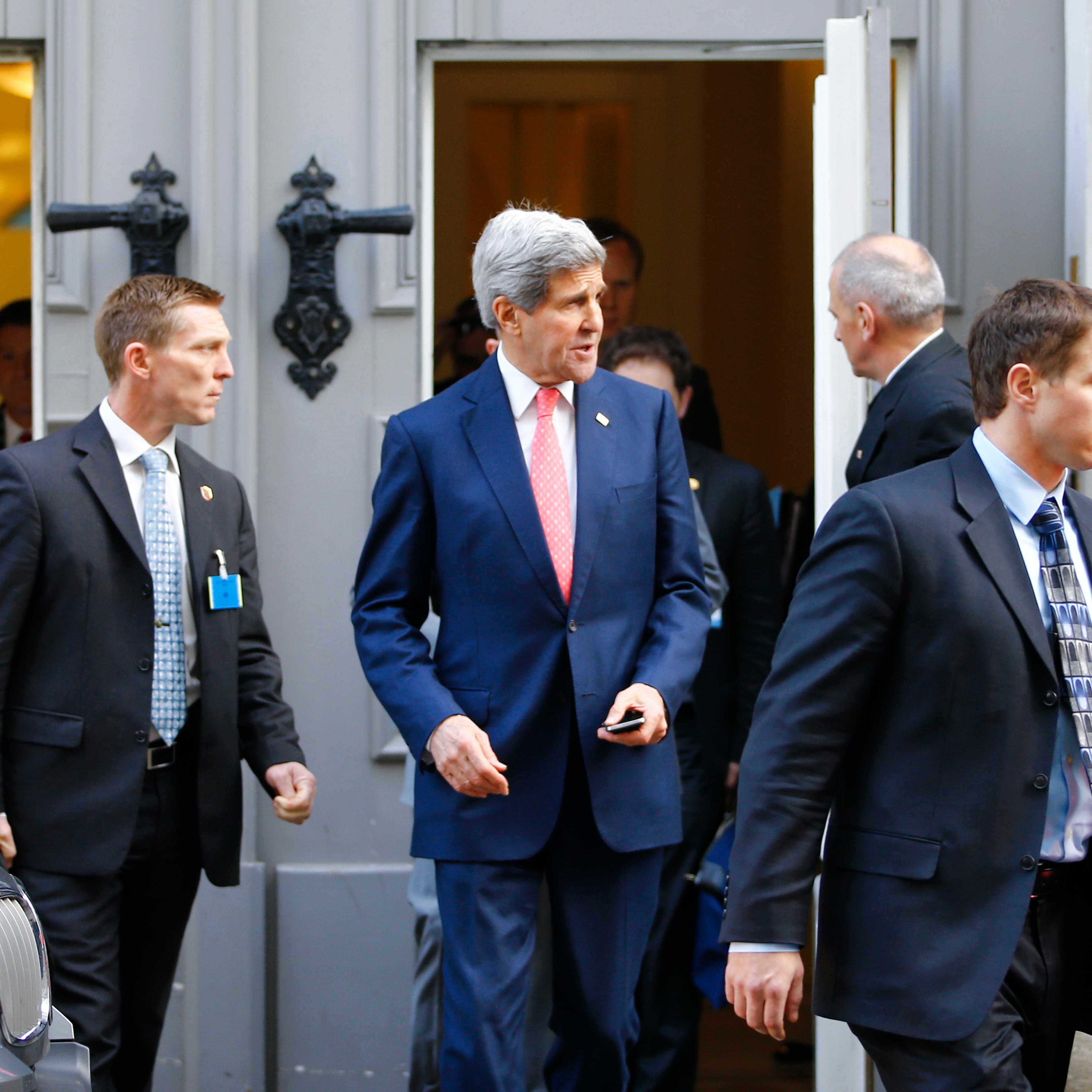U.S. Secretary of State Kerry is surrounded by security as he leaves after a meeting in Vienna
