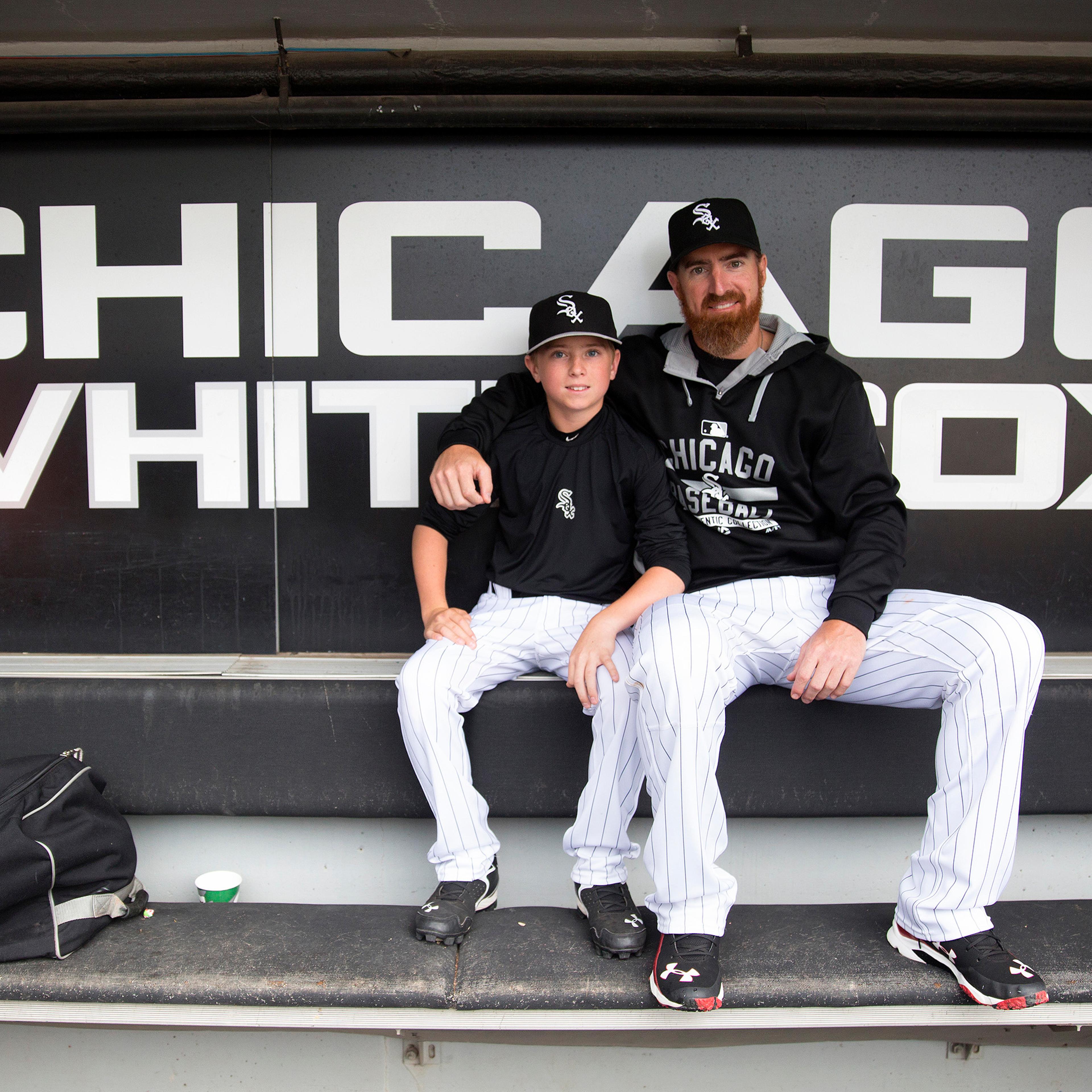 Chicago White Sox designated hitter Adam LaRoche (25) sits with his son Drake, 13, in the White Sox dugout at U.S. Cellular Field before a game against the Houston Astros on June 8, 2015 in Chicago.