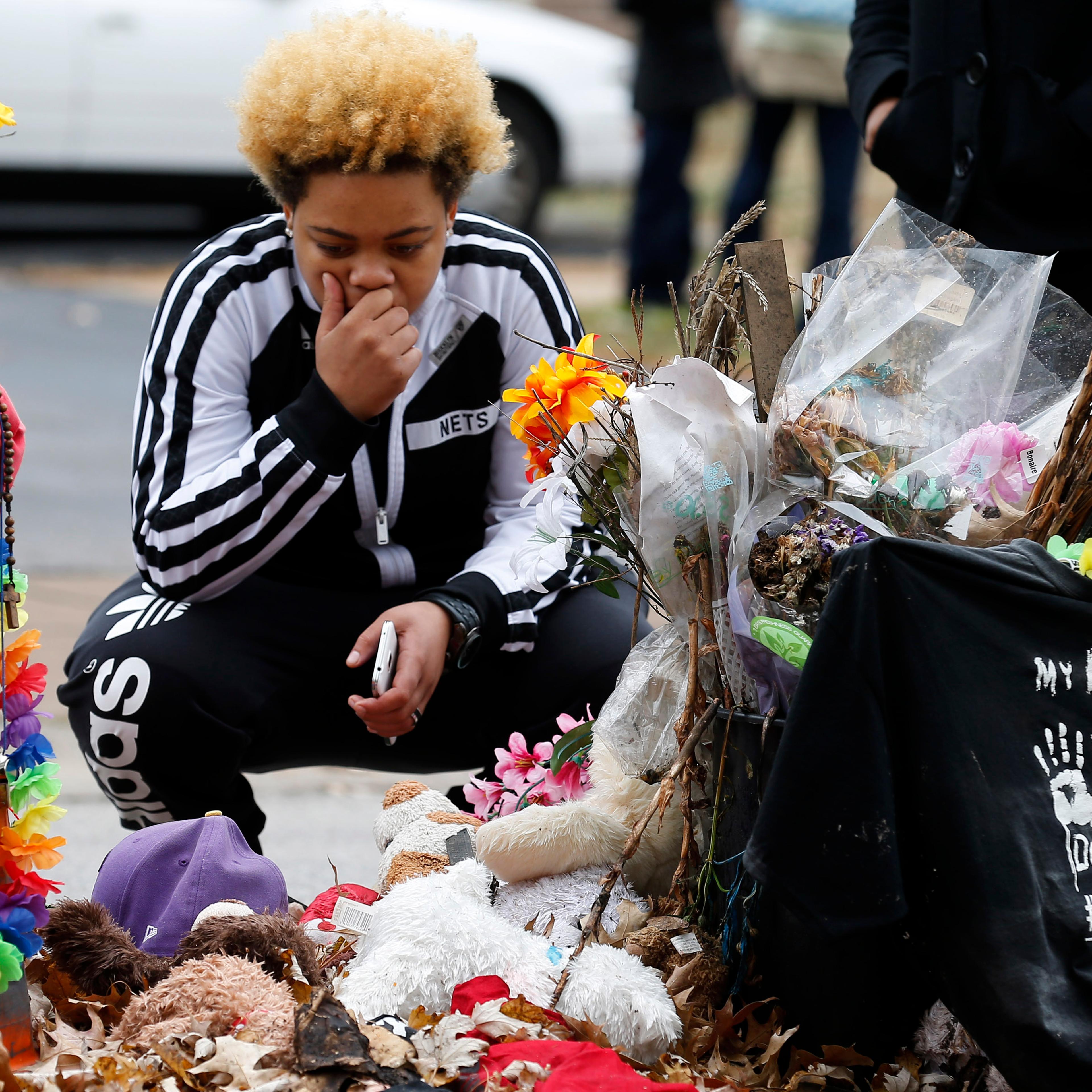 Woman stops to visit the memorial set up where Michael Brown was shot and killed in Ferguson
