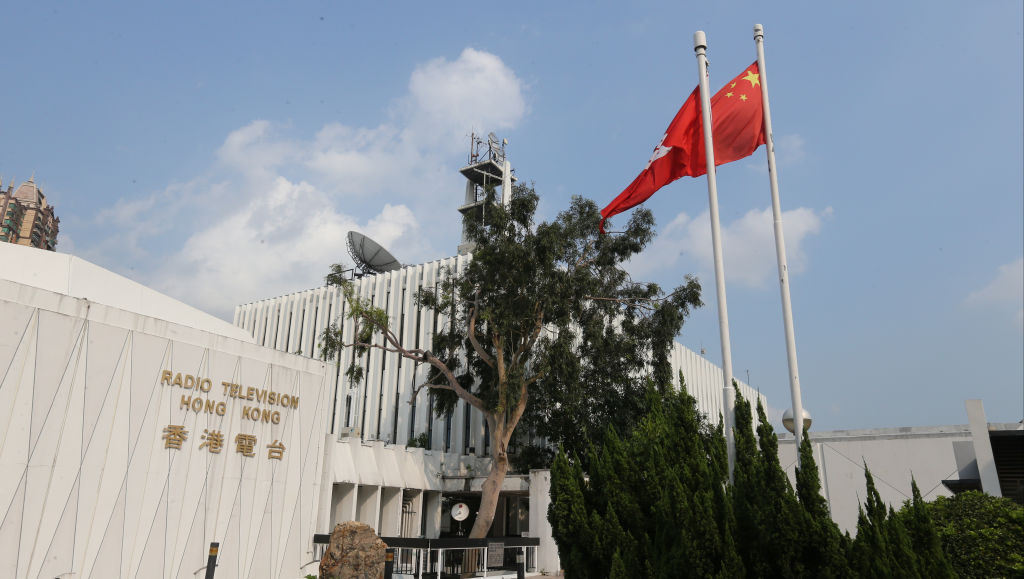 A Chinese national flag and Hong Kong flag flutter in fornt of Radio Television Hong Kong in Kowloon Tong.  06AUG15