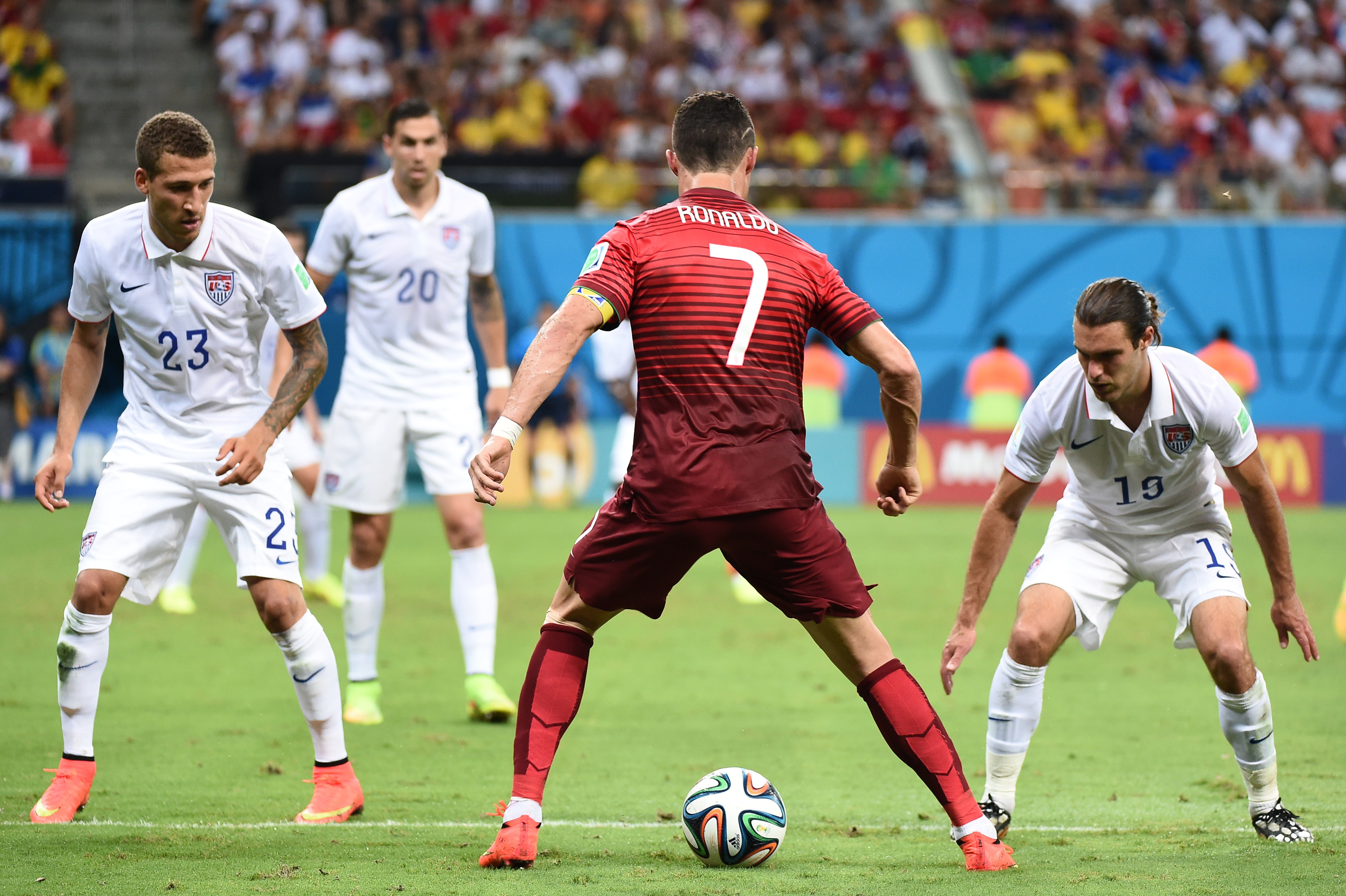 U.S. midfielder Graham Zusi (right) and US defender Fabian Johnson (left) defend against Portugal's forward Cristiano Ronaldo (second from right) during a Group G match between USA and Portugal at the Amazonia Arena in Manaus during the 2014 FIFA World C